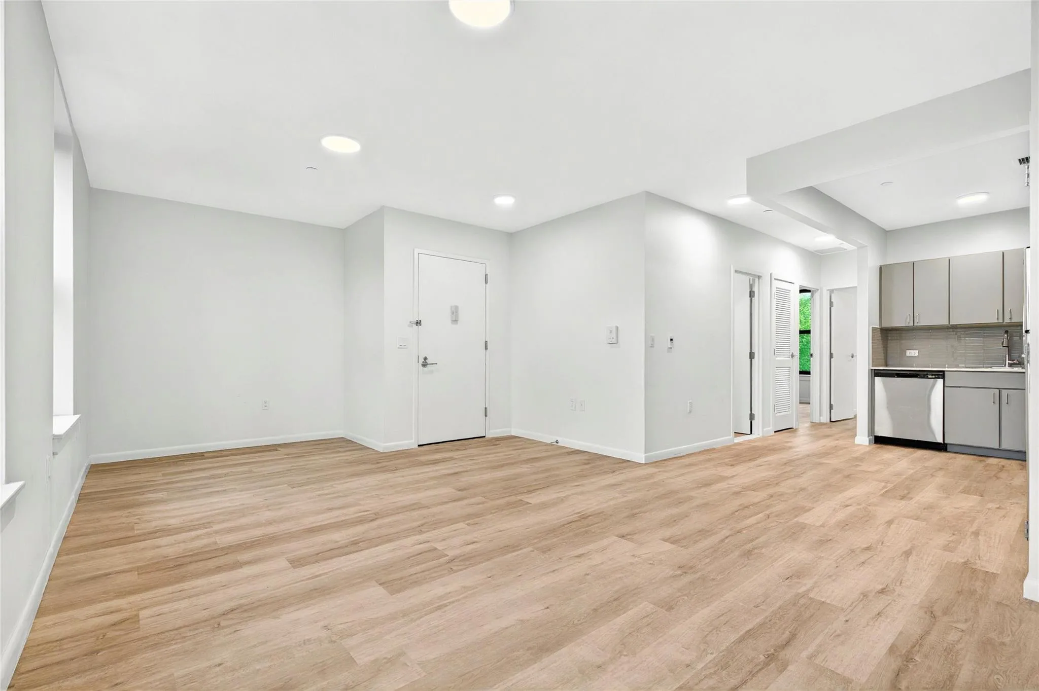 Unfurnished living room with light wood finished floors, baseboards, a sink, and recessed lighting Unfurnished living room with light wood finished floors, baseboards, a sink, and recessed lighting