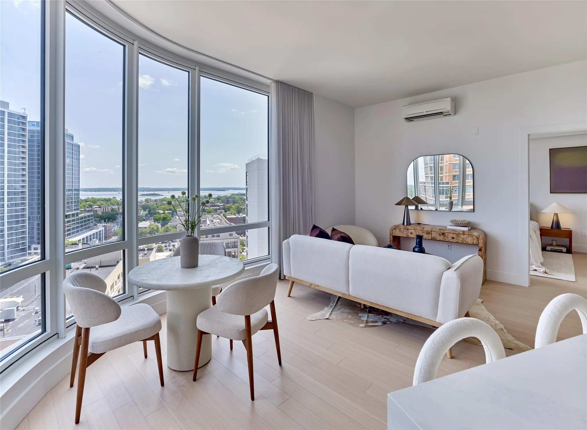 Dining area featuring a view of city, light wood-style flooring, and a wall mounted air conditioner Dining area featuring a view of city, light wood-style flooring, and a wall mounted air conditioner