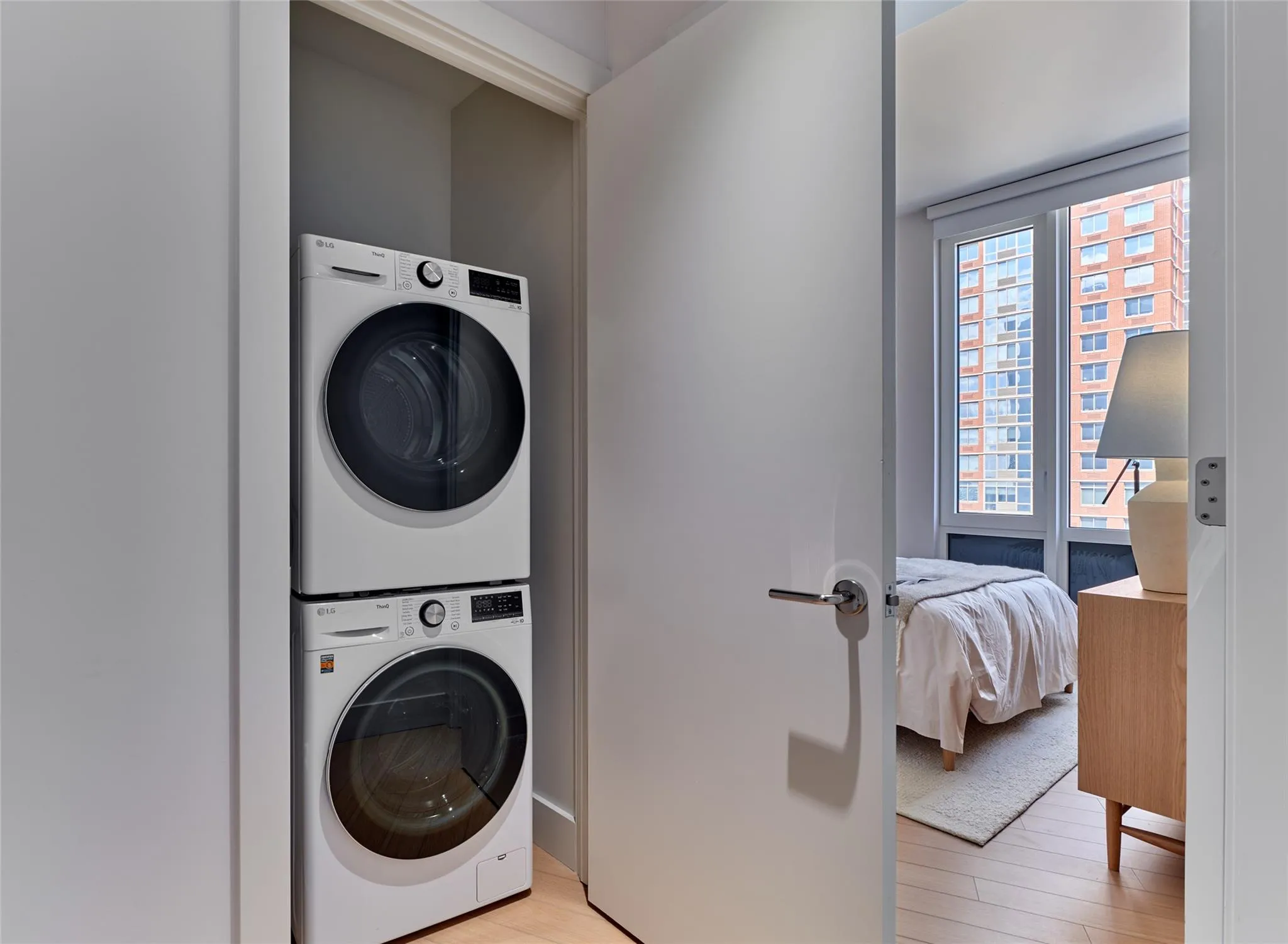 Washroom with estacked washer and dryer and light wood finished floors Washroom with estacked washer and dryer and light wood finished floors