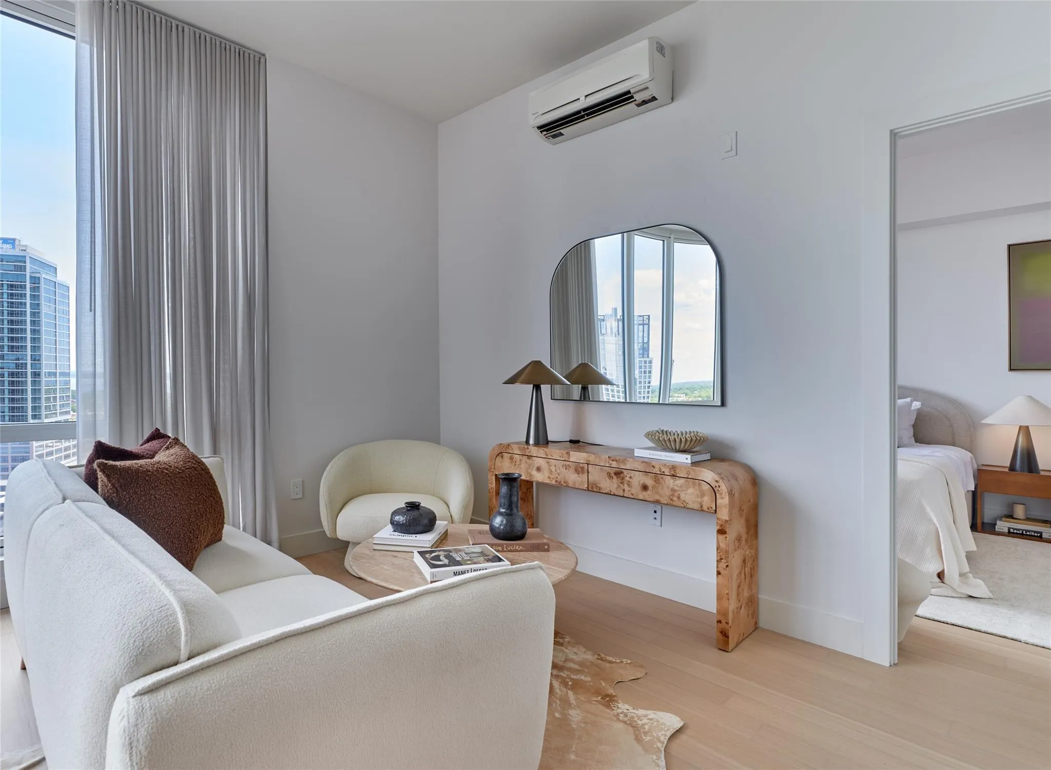 Sitting room featuring wood finished floors, healthy amount of natural light, and a wall mounted air conditioner Sitting room featuring wood finished floors, healthy amount of natural light, and a wall mounted air conditioner