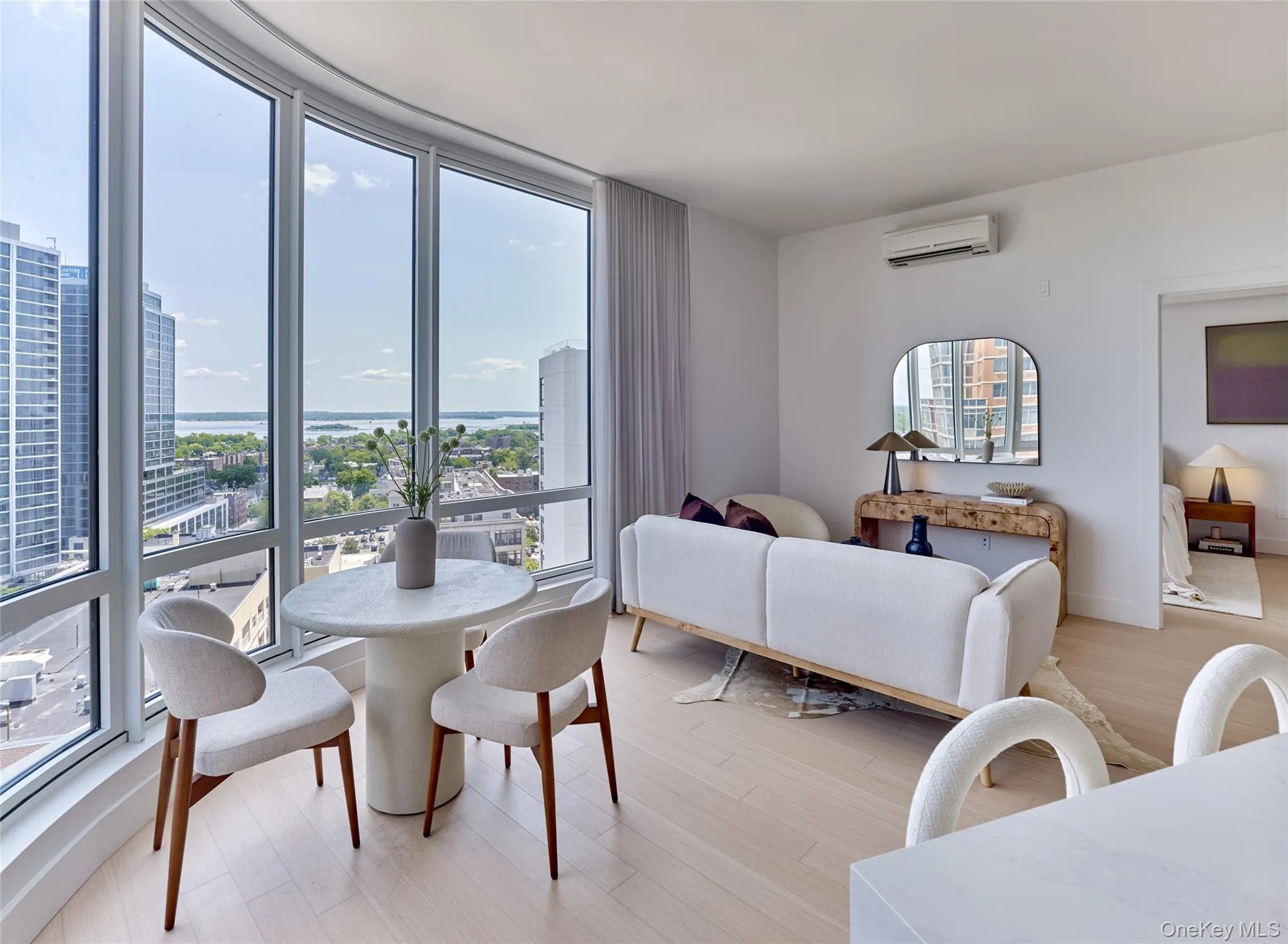 Dining area featuring a view of city, light wood-style flooring, and a wall mounted air conditioner Dining area featuring a view of city, light wood-style flooring, and a wall mounted air conditioner