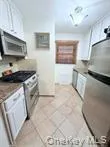 Kitchen with stainless steel microwave and light tile patterned floors Kitchen with stainless steel microwave and light tile patterned floors