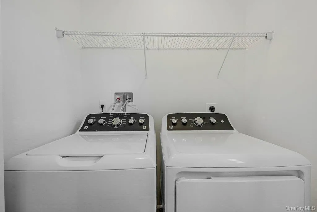 Laundry room with washer and dryer located on the first floor with half bath Laundry room with washer and dryer located on the first floor with half bath