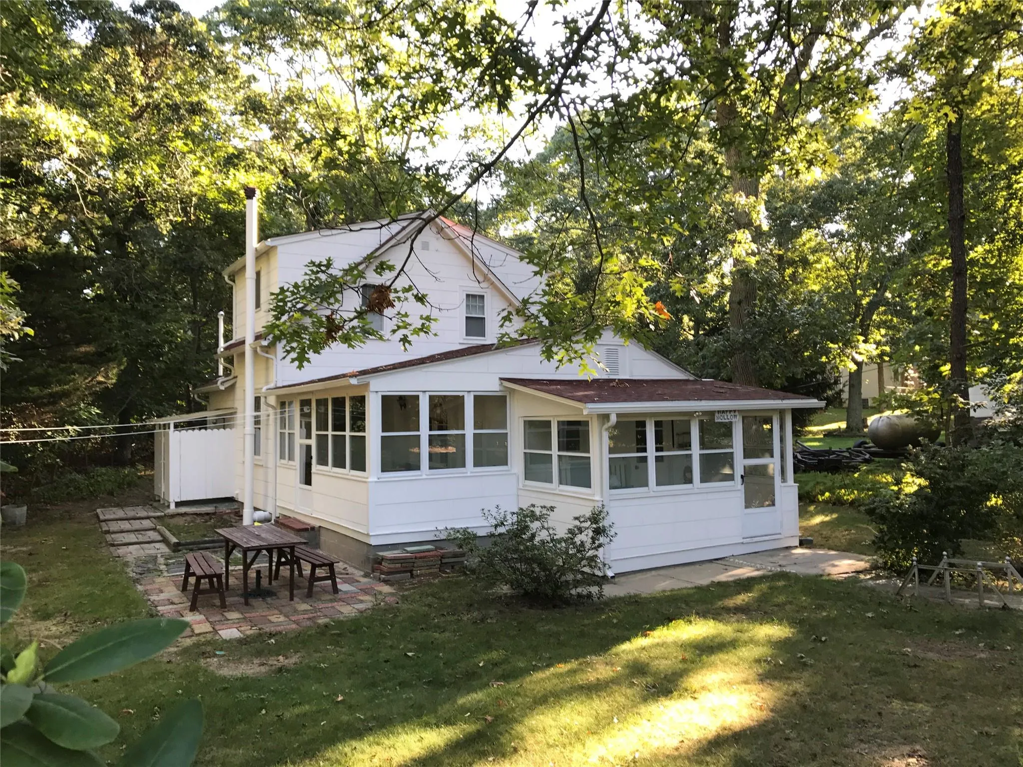 Back of house with a sunroom and a patio area Back of house with a sunroom and a patio area