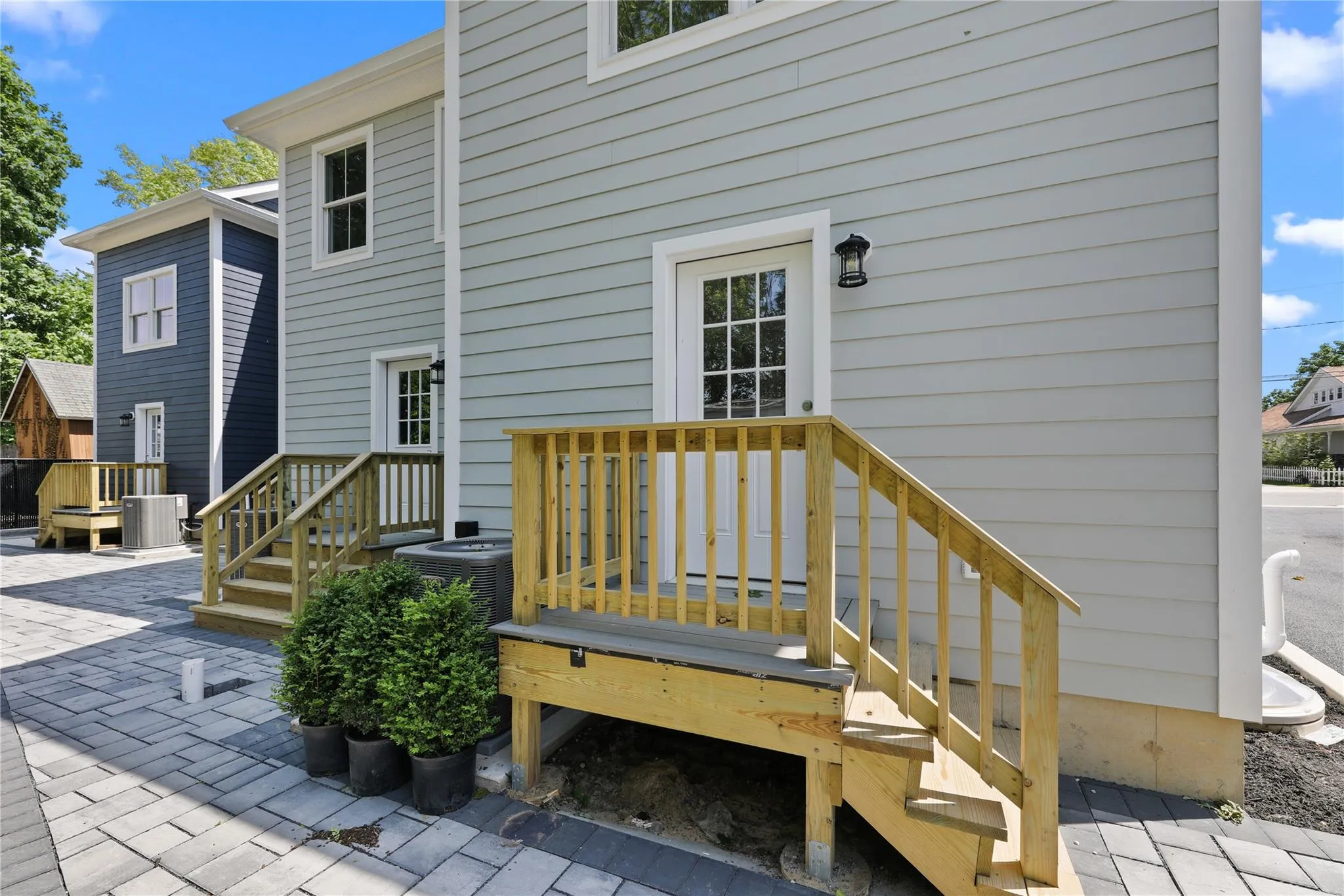 Back of apartments featuring a patio area and a deck Back of apartments featuring a patio area and a deck