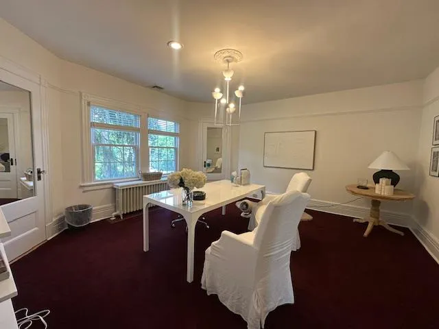 Home office featuring radiator heating unit and carpet flooring Home office featuring radiator heating unit and carpet flooring