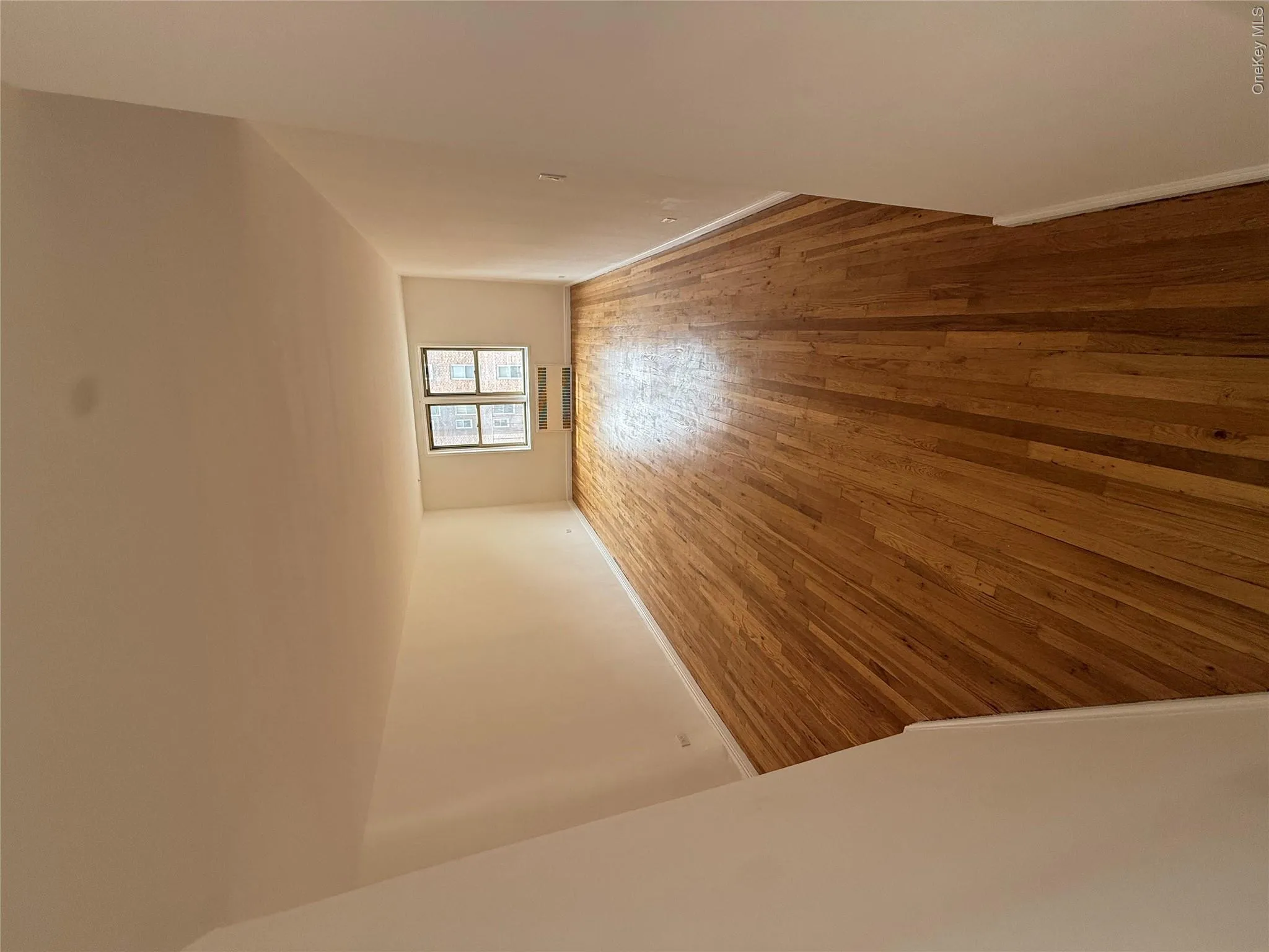 Spare room featuring hardwood / wood-style flooring and a wall mounted AC Spare room featuring hardwood / wood-style flooring and a wall mounted AC