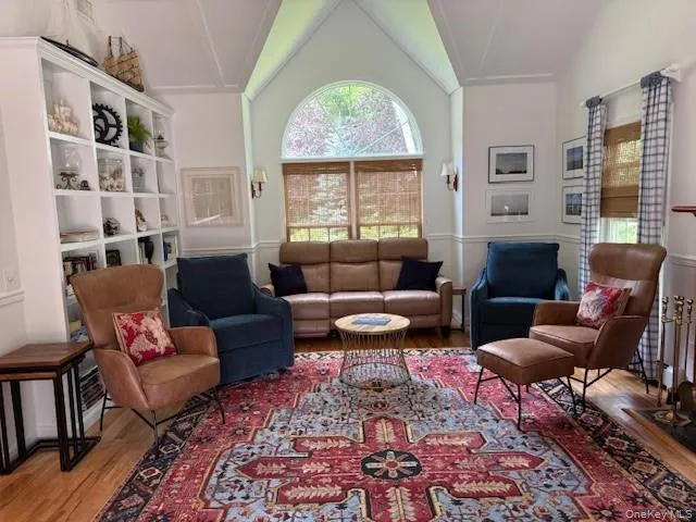 Living area featuring wood finished floors and vaulted ceiling Living area featuring wood finished floors and vaulted ceiling