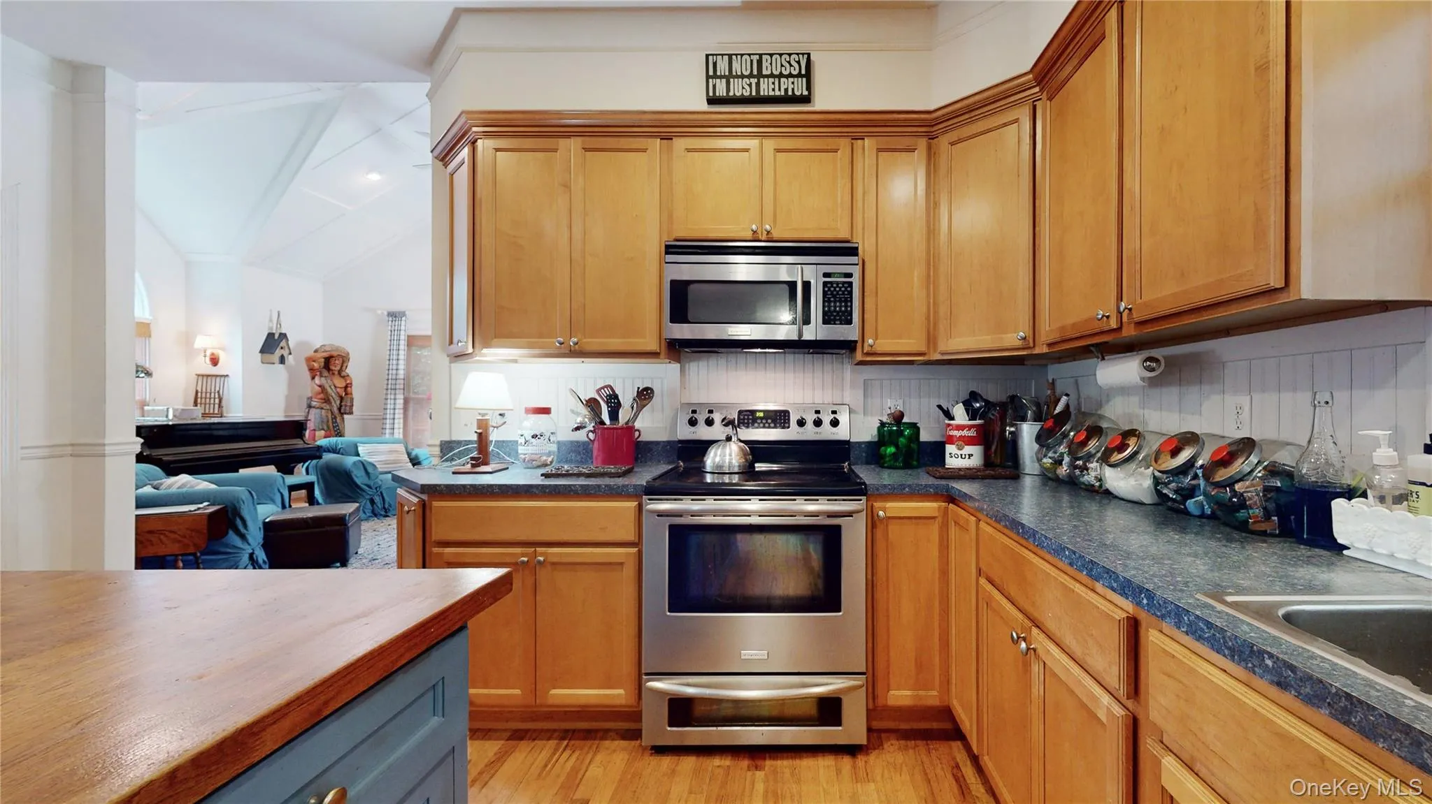 Kitchen with stainless steel appliances, tasteful backsplash, light wood finished floors, butcher block counters, and brown cabinets Kitchen with stainless steel appliances, tasteful backsplash, light wood finished floors, butcher block counters, and brown cabinets