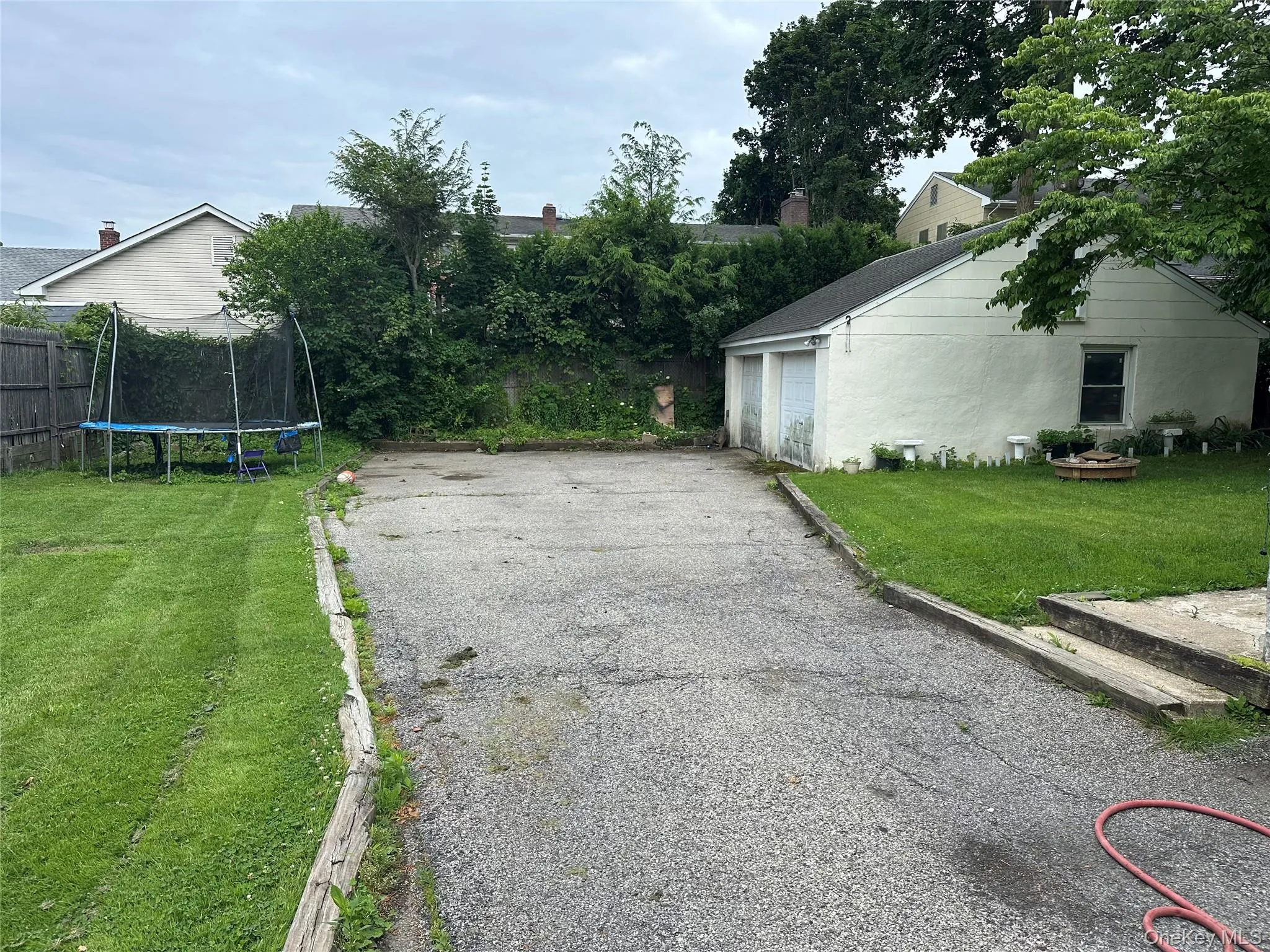 View of grassy yard with a trampoline and a garage View of grassy yard with a trampoline and a garage