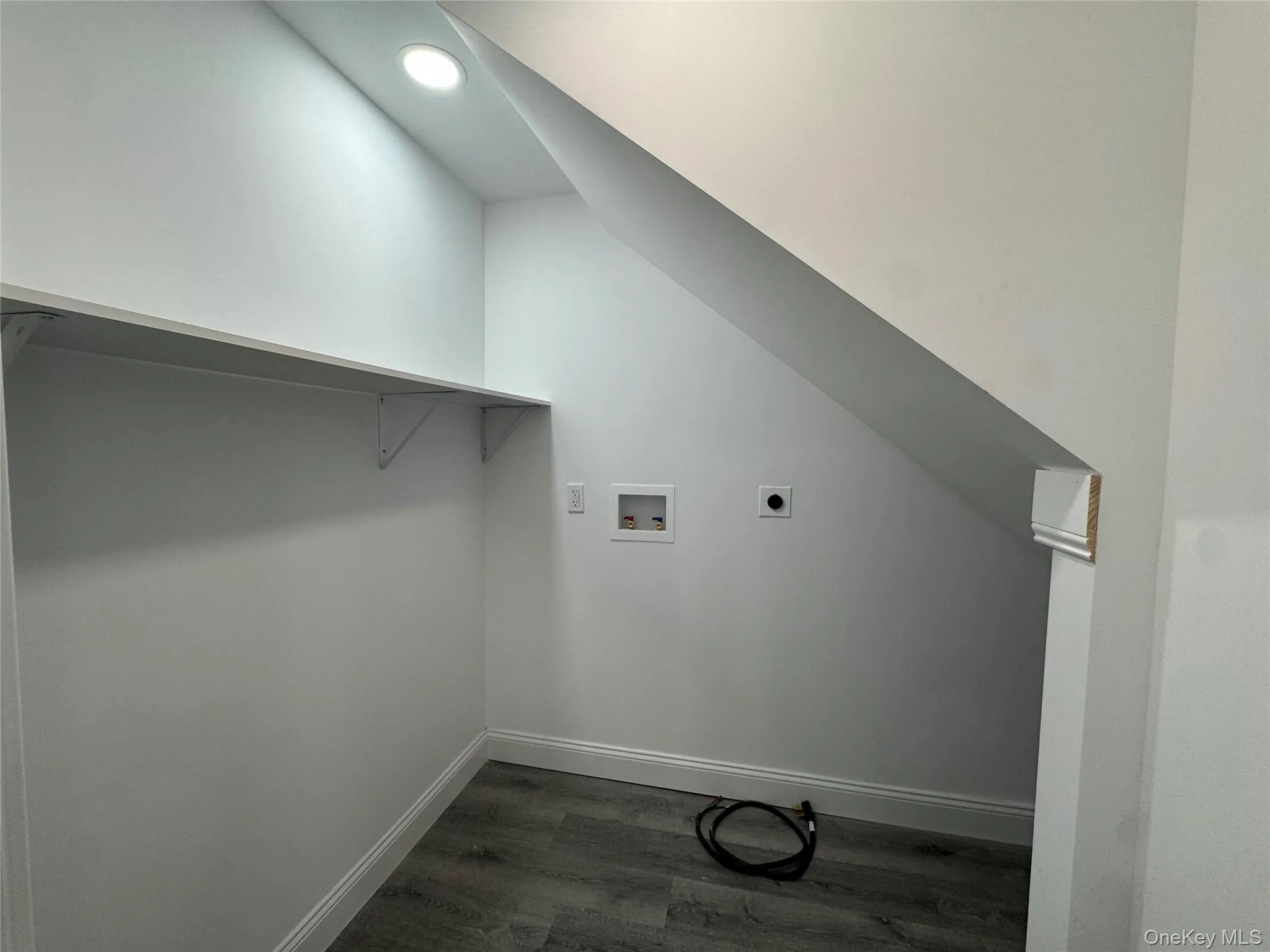 Washroom featuring dark wood finished floors, hookup for a washing machine, and hookup for an electric dryer Washroom featuring dark wood finished floors, hookup for a washing machine, and hookup for an electric dryer