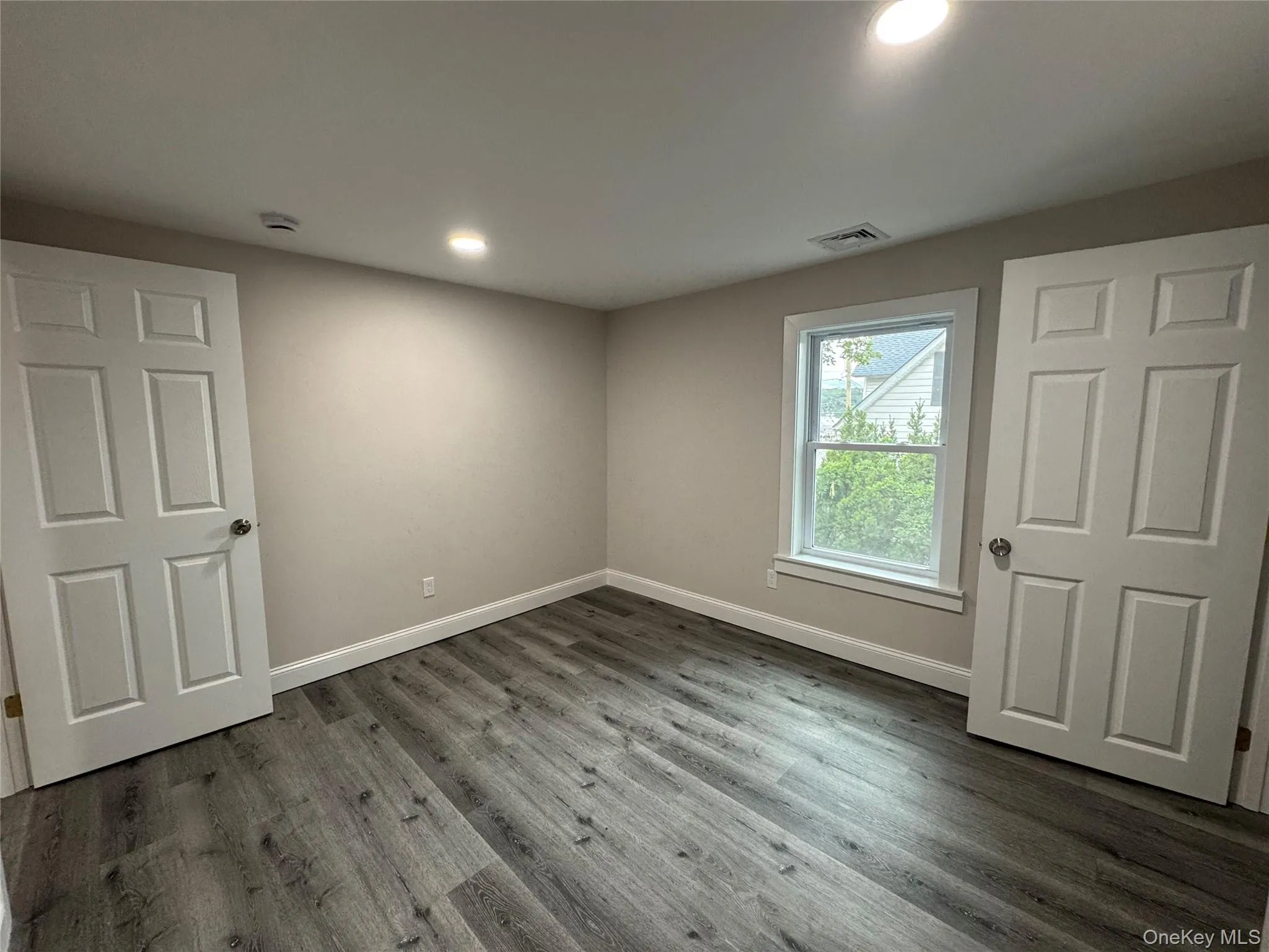 Unfurnished bedroom featuring wood finished floors and recessed lighting Unfurnished bedroom featuring wood finished floors and recessed lighting