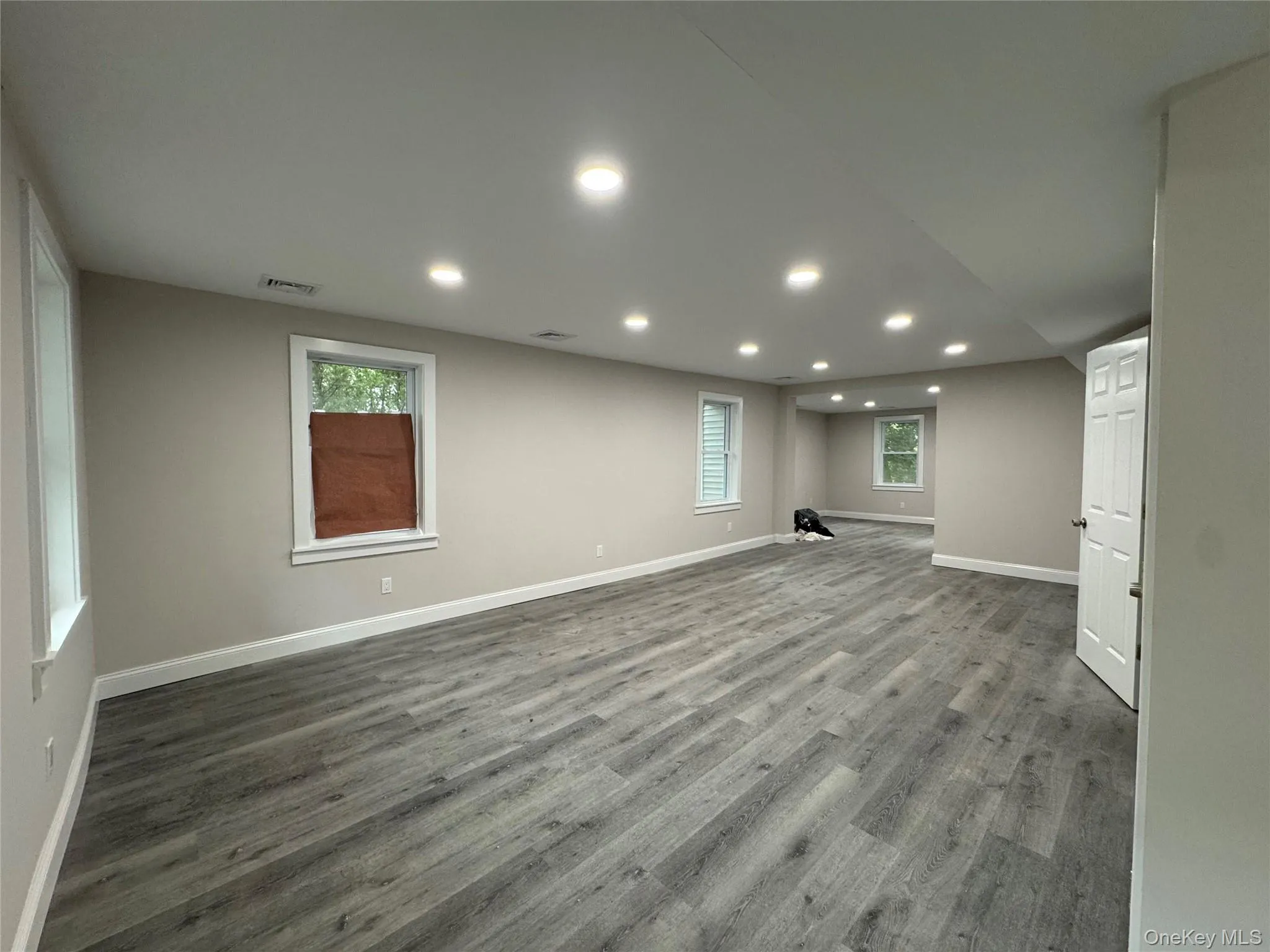 Basement with dark wood-type flooring, recessed lighting, and plenty of natural light Basement with dark wood-type flooring, recessed lighting, and plenty of natural light