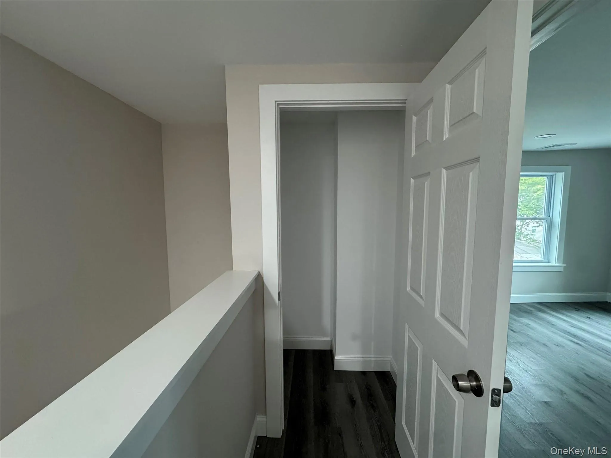 Hallway with dark wood finished floors and an upstairs landing Hallway with dark wood finished floors and an upstairs landing