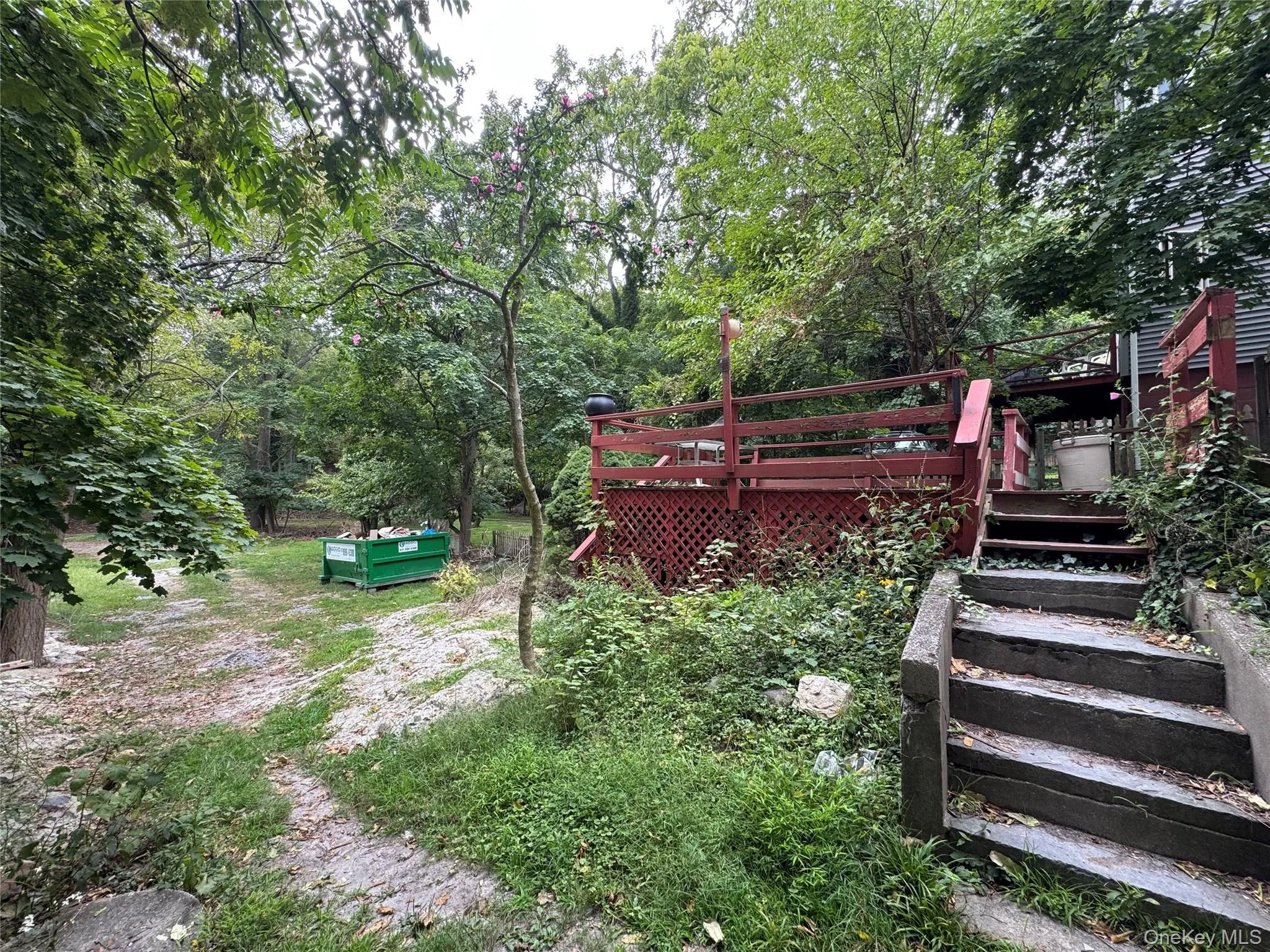 View of yard featuring a wooden deck and a forest view View of yard featuring a wooden deck and a forest view