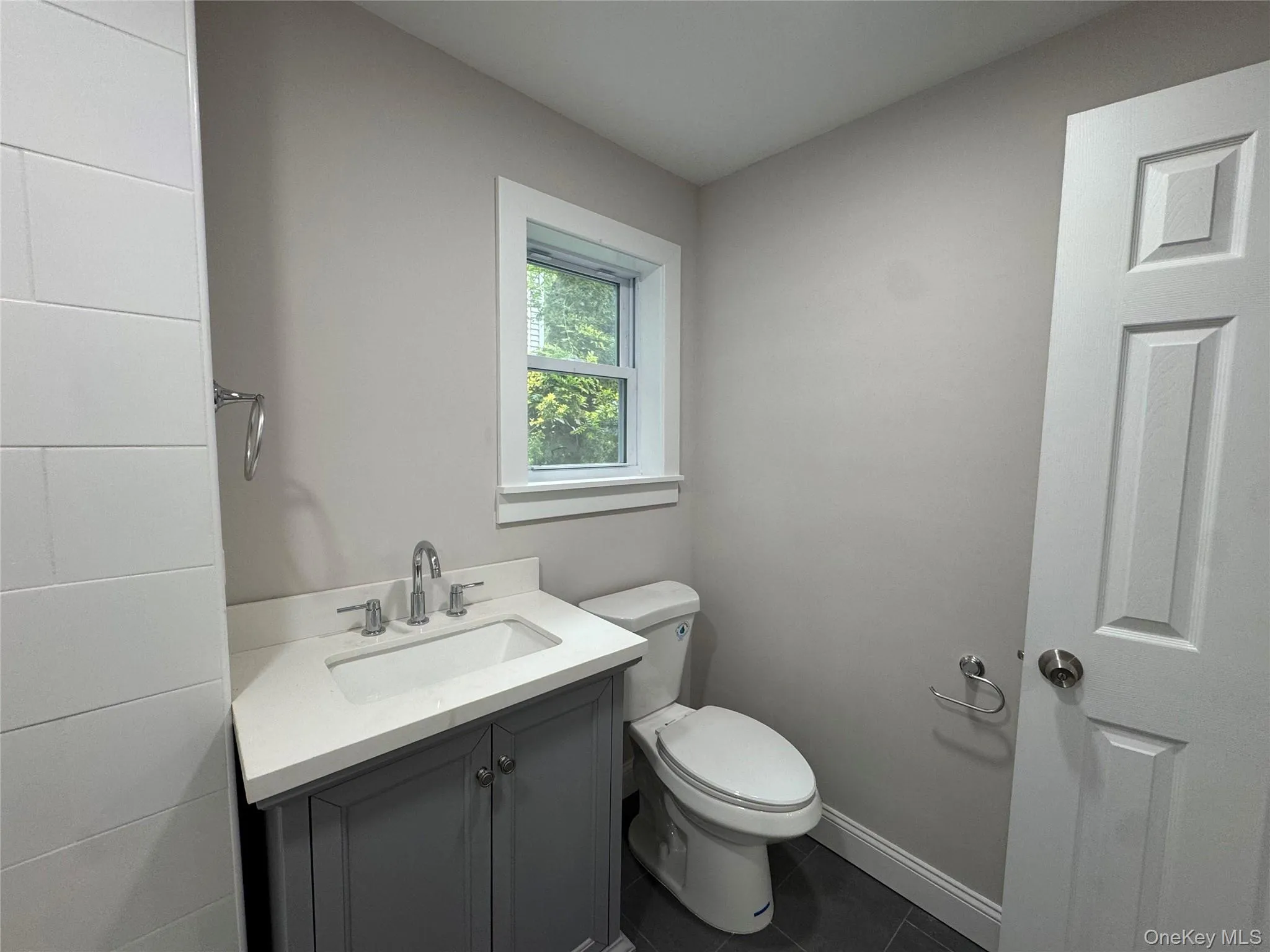 Bathroom with vanity and dark tile patterned flooring Bathroom with vanity and dark tile patterned flooring