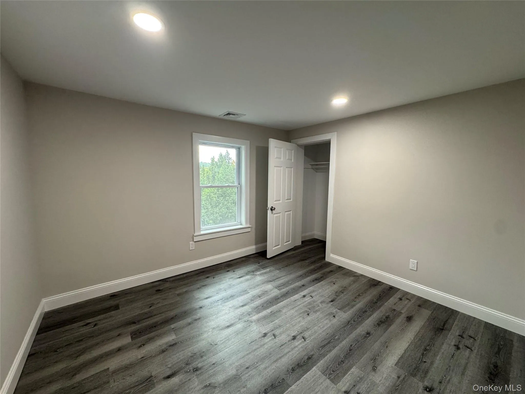 Unfurnished bedroom with wood finished floors and recessed lighting Unfurnished bedroom with wood finished floors and recessed lighting