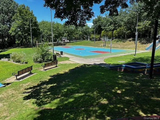 View of sport court featuring a lawn, community basketball court, and view of scattered trees View of sport court featuring a lawn, community basketball court, and view of scattered trees