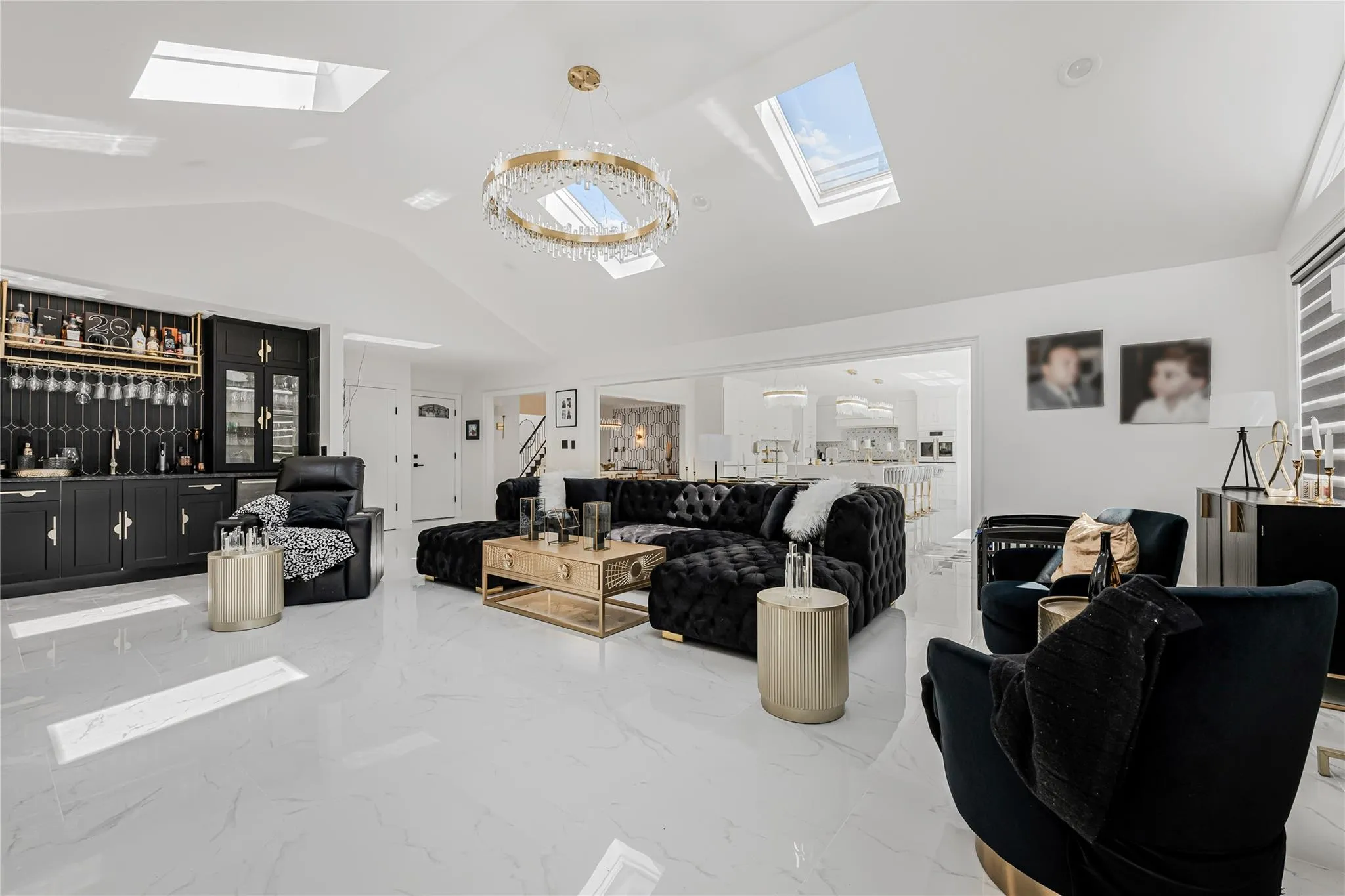 Living room with a skylight, vaulted ceiling, bar area, and marble tiled flooring Living room with a skylight, vaulted ceiling, bar area, and marble tiled flooring