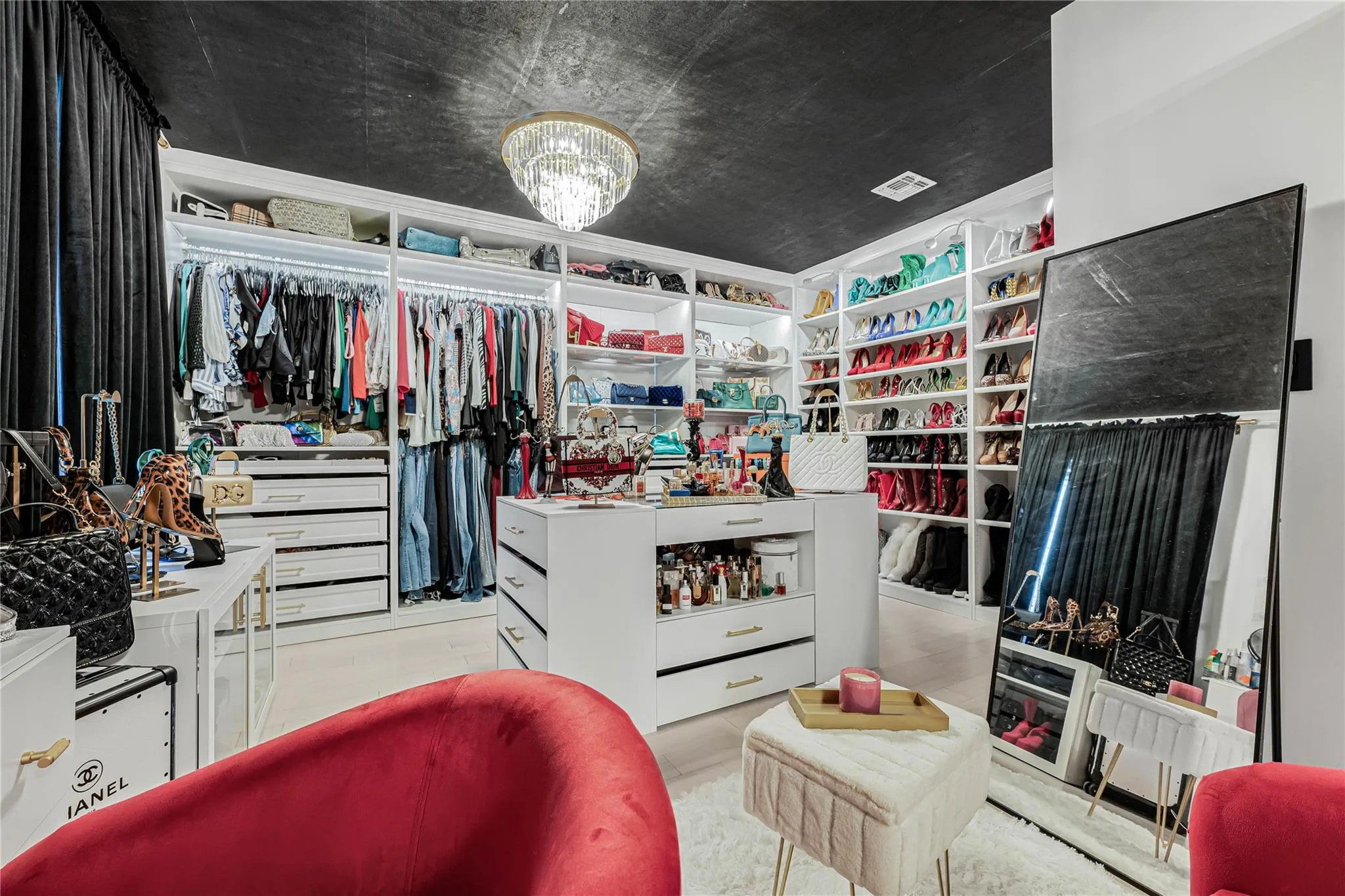 Walk in closet featuring a chandelier Walk in closet featuring a chandelier