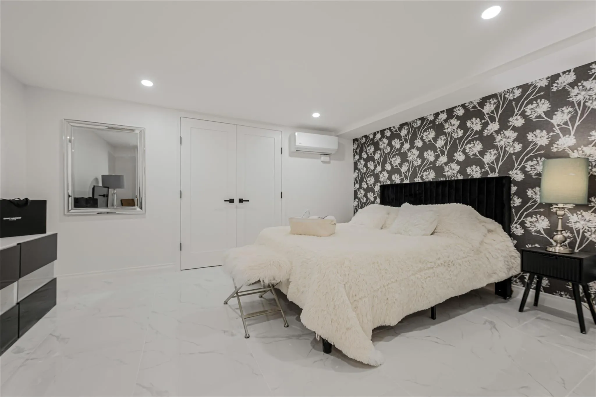 Bedroom featuring an AC wall unit, recessed lighting, light marble finish floors, and a closet Bedroom featuring an AC wall unit, recessed lighting, light marble finish floors, and a closet