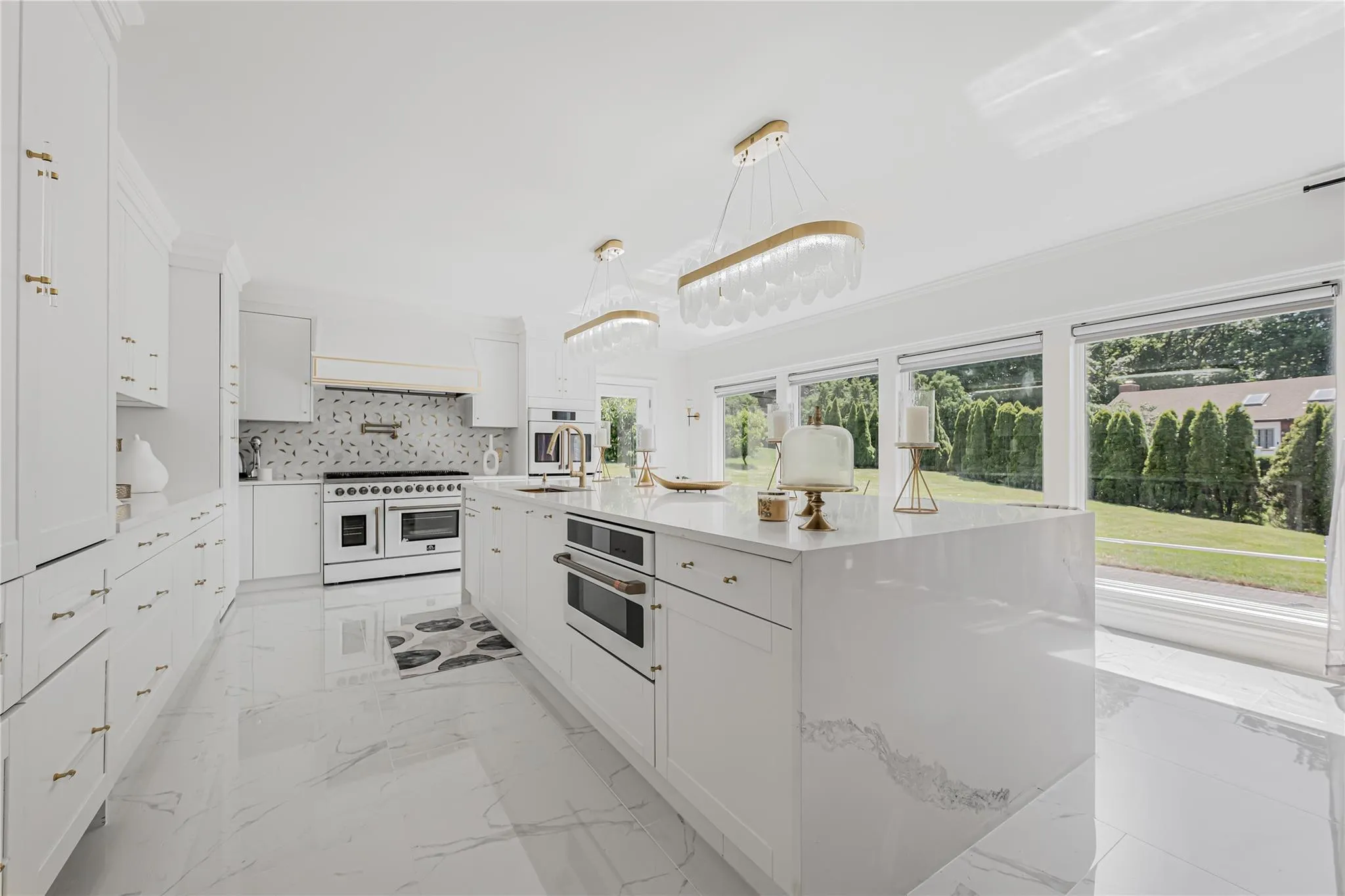 Kitchen featuring white appliances, plenty of natural light, white cabinetry, and light countertops Kitchen featuring white appliances, plenty of natural light, white cabinetry, and light countertops