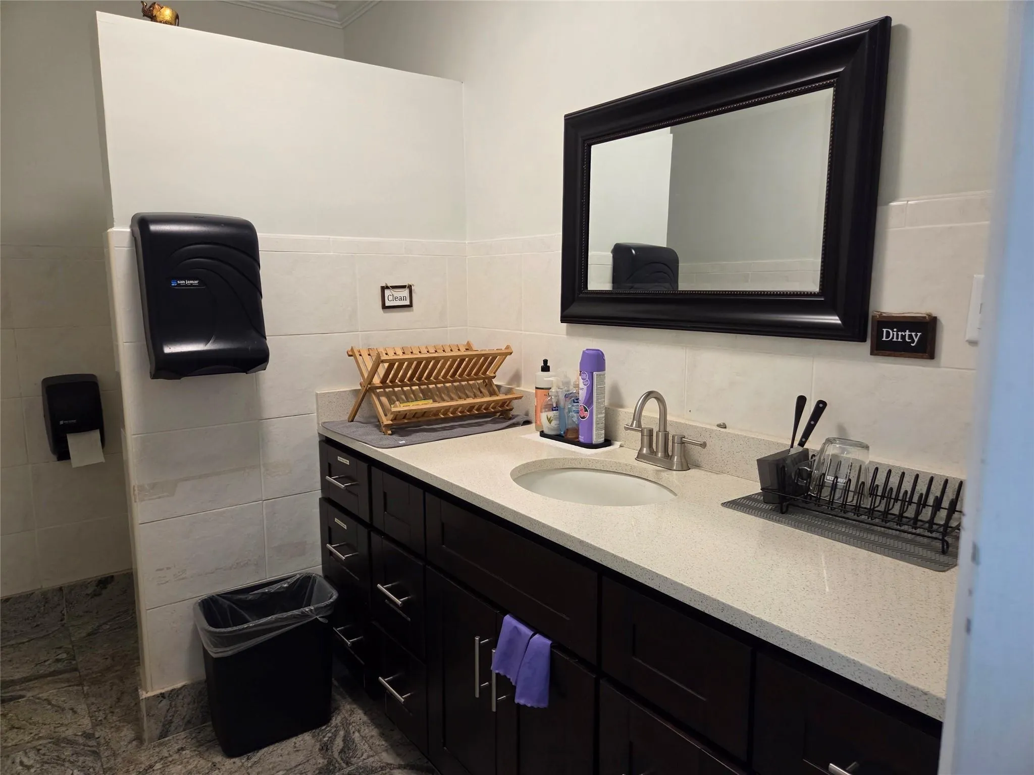 Bathroom with tile walls, vanity, ornamental molding, and wainscoting Bathroom with tile walls, vanity, ornamental molding, and wainscoting