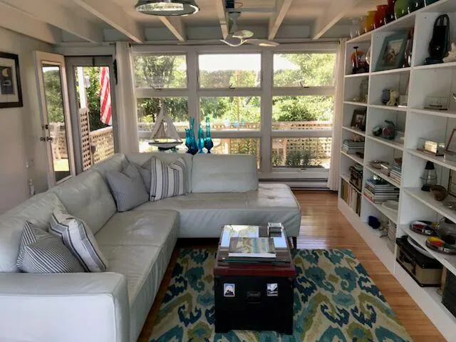 Living area with wood finished floors, a baseboard radiator, and beam ceiling Living area with wood finished floors, a baseboard radiator, and beam ceiling