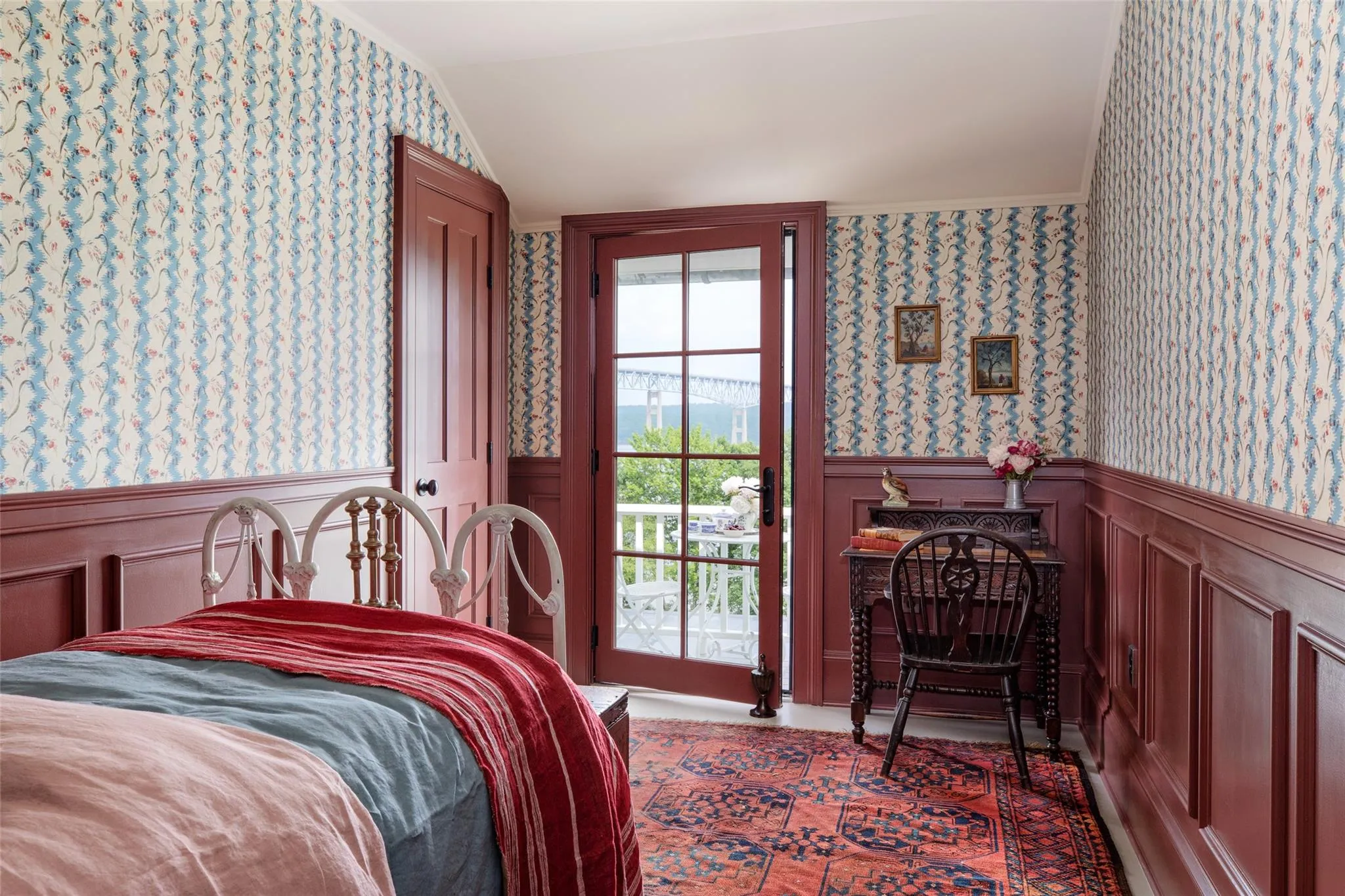 Bedroom with wallpapered walls, access to exterior, a wainscoted wall, lofted ceiling, and a decorative wall Bedroom with wallpapered walls, access to exterior, a wainscoted wall, lofted ceiling, and a decorative wall