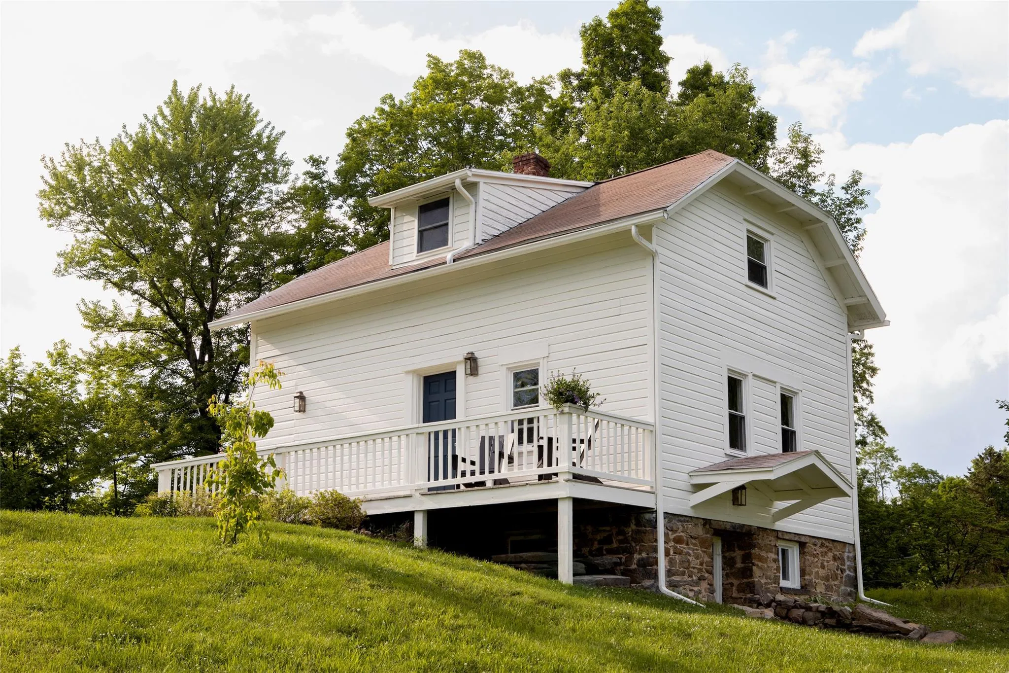 Back of property with a wooden deck, a chimney, and a yard Back of property with a wooden deck, a chimney, and a yard