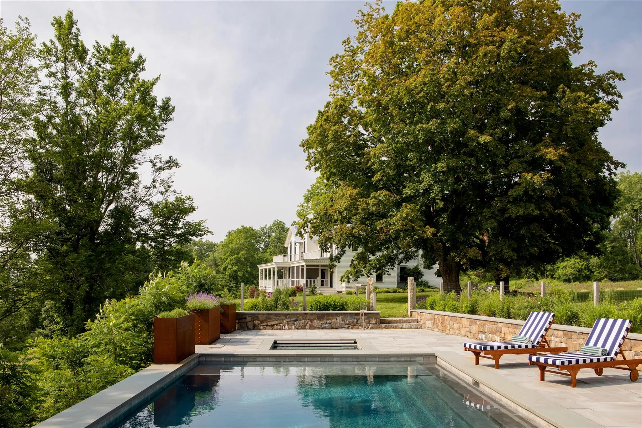 Swimming pool featuring an in-ground hot tub and a patio area Swimming pool featuring an in-ground hot tub and a patio area