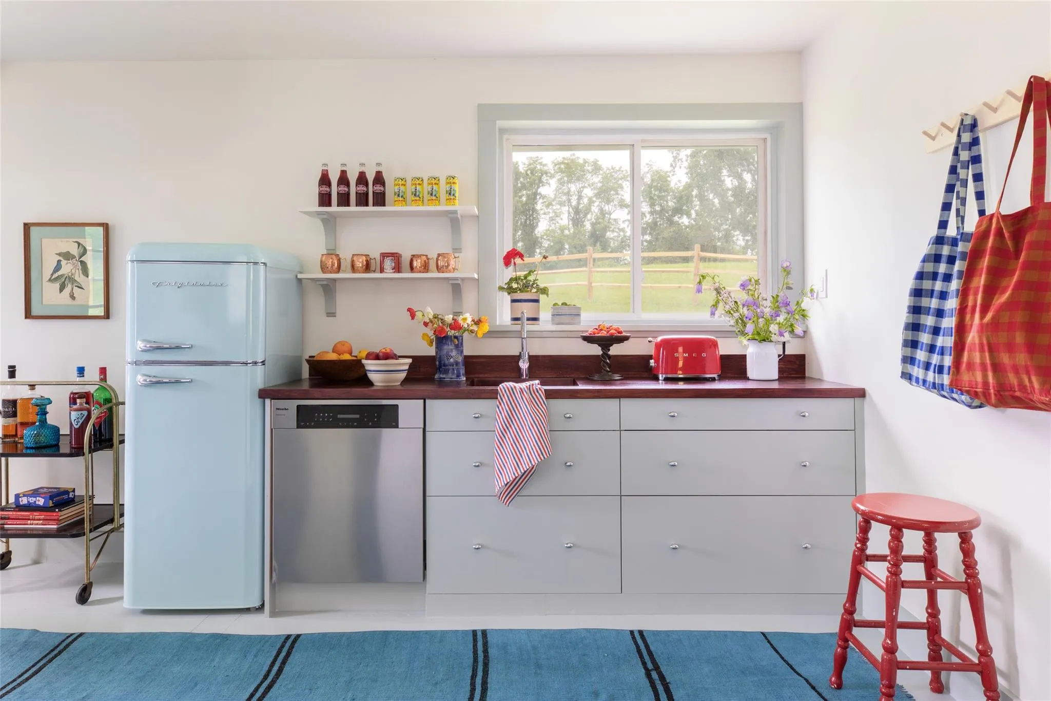 Kitchen with stainless steel dishwasher, freestanding refrigerator, white cabinets, and butcher block countertops Kitchen with stainless steel dishwasher, freestanding refrigerator, white cabinets, and butcher block countertops