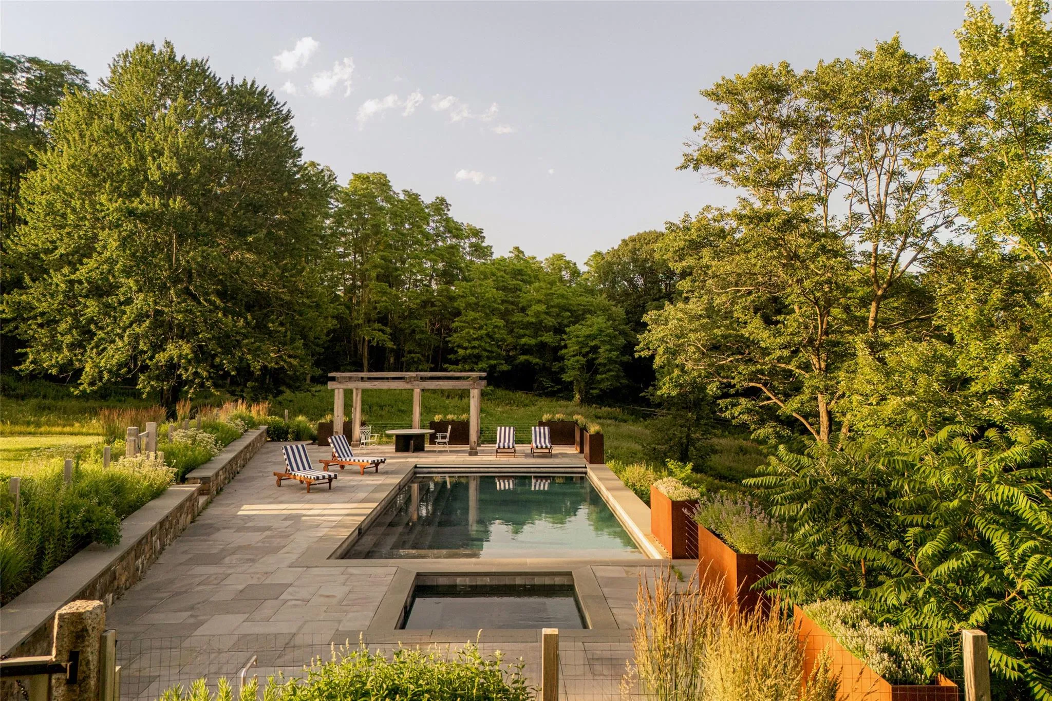 Swimming pool with a pergola, a patio area, and an in-ground hot tub Swimming pool with a pergola, a patio area, and an in-ground hot tub