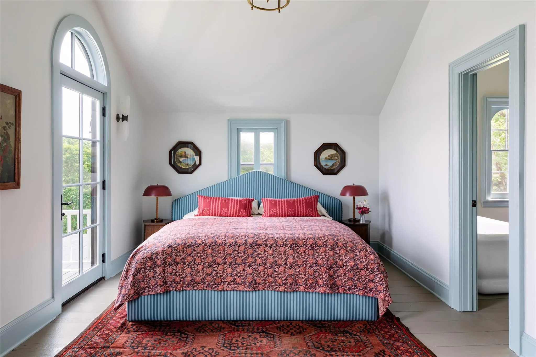 Bedroom with vaulted ceiling, access to outside, multiple windows, and light tile patterned flooring Bedroom with vaulted ceiling, access to outside, multiple windows, and light tile patterned flooring
