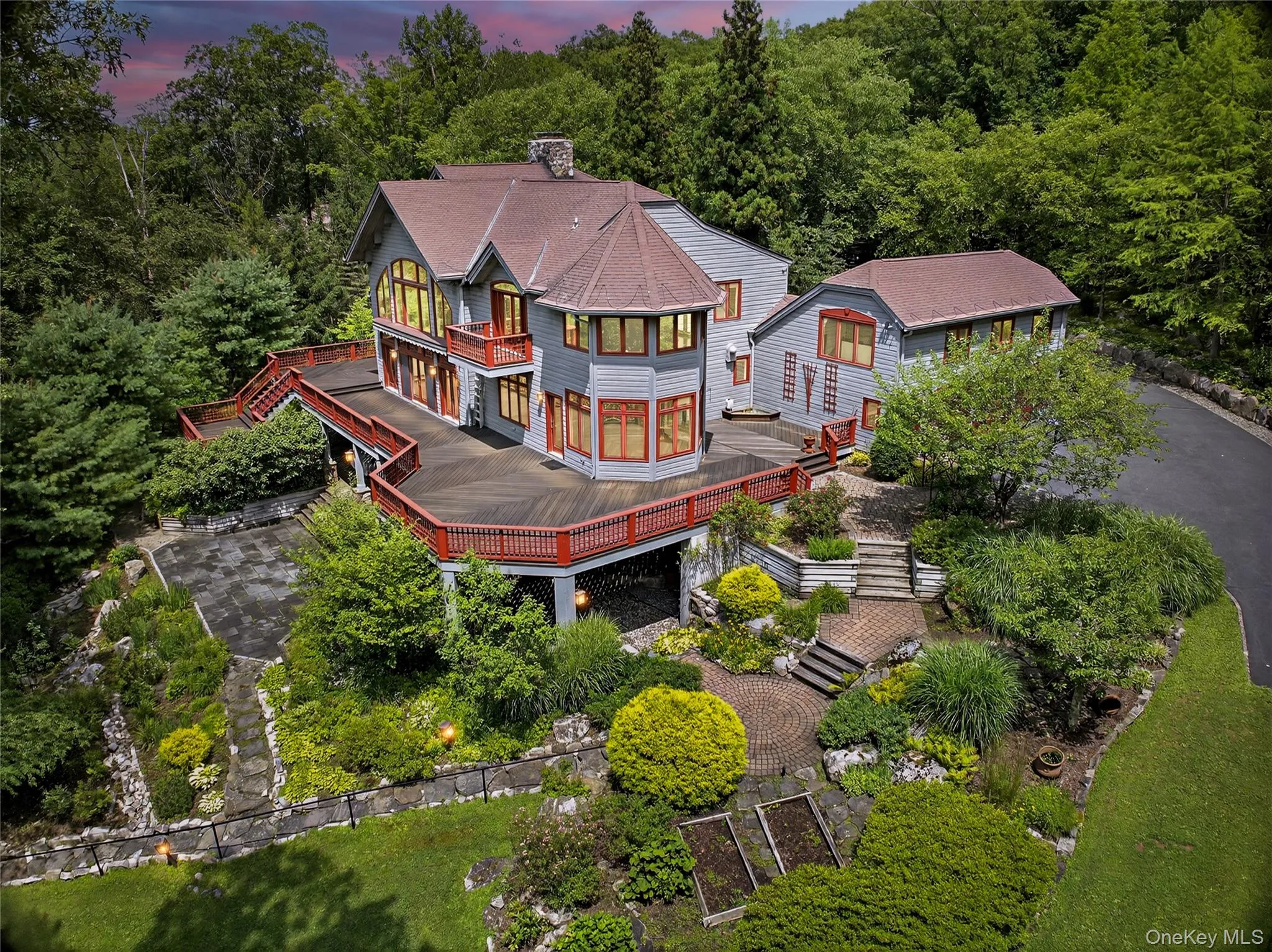 Back of property at dusk with a balcony, stairs, a wooden deck, roof with shingles, and a chimney Back of property at dusk with a balcony, stairs, a wooden deck, roof with shingles, and a chimney