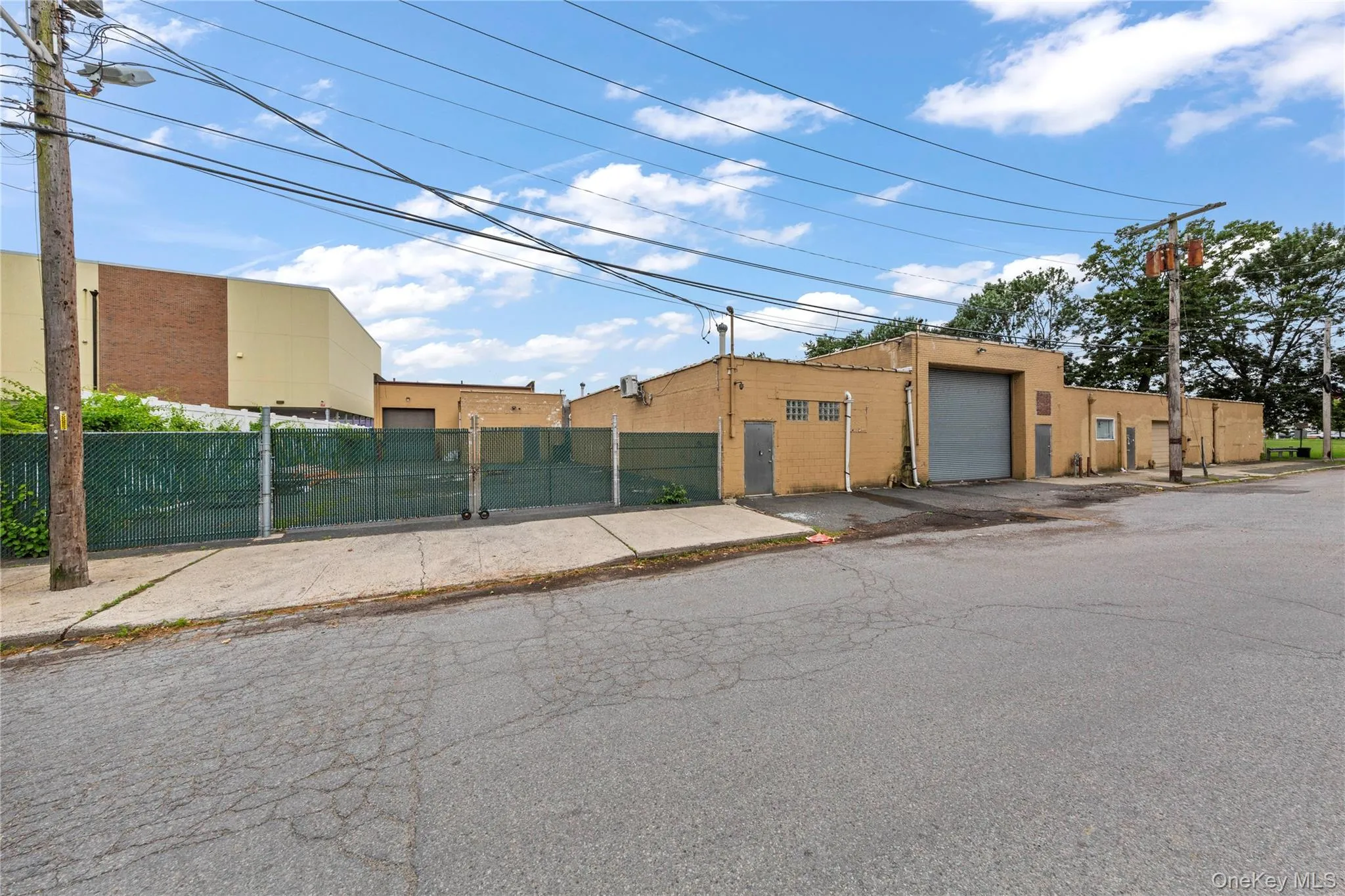 View of building exterior featuring a fenced front yard and a garage View of building exterior featuring a fenced front yard and a garage