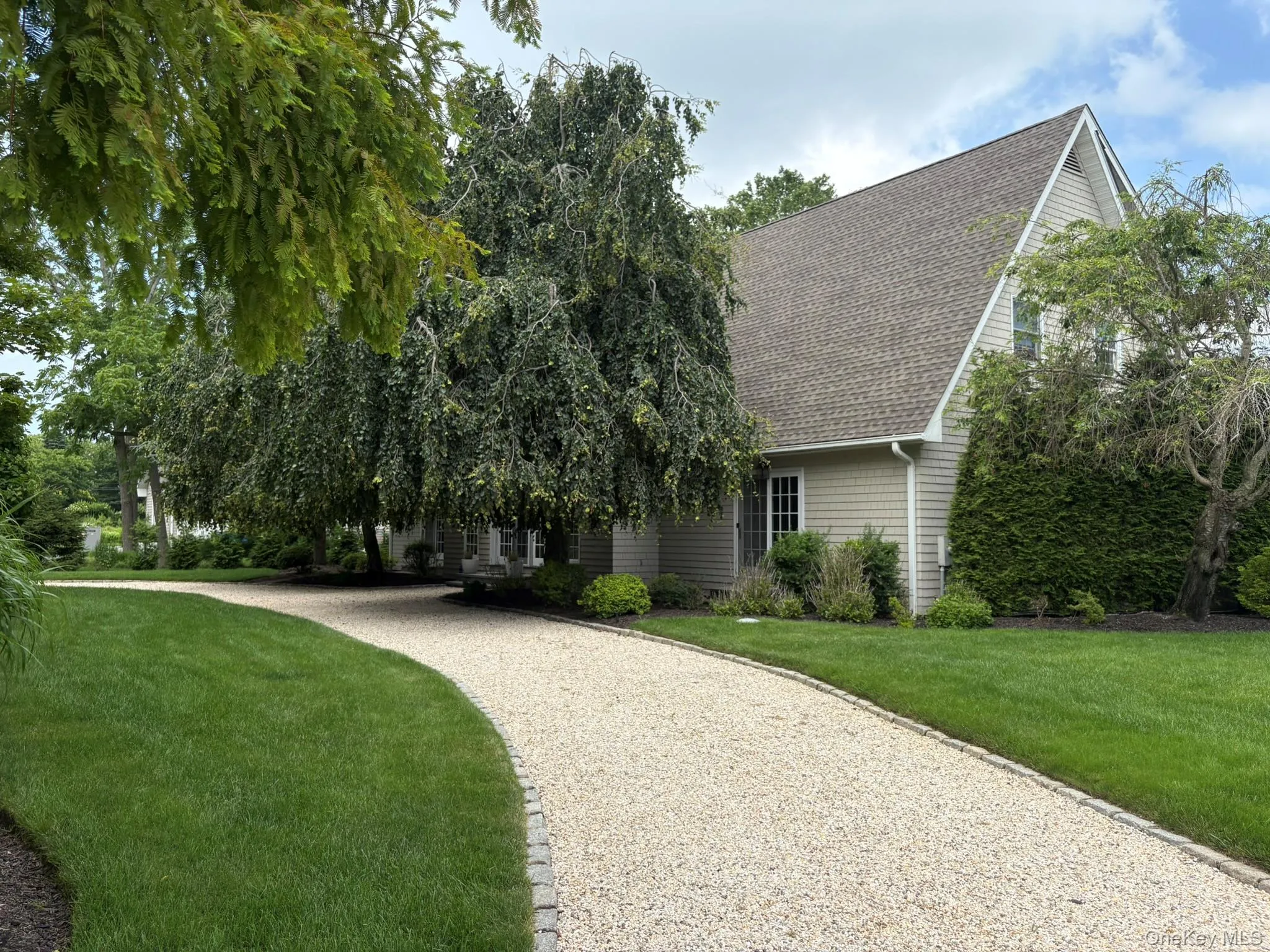 View of front of property with roof with shingles, driveway, and a front yard View of front of property with roof with shingles, driveway, and a front yard