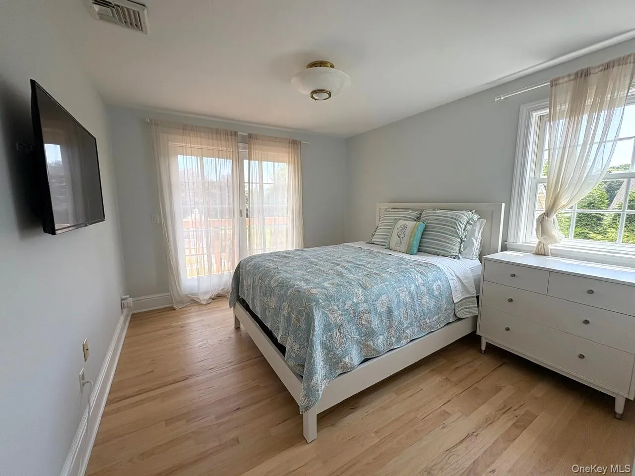 Bedroom with light wood finished floors and baseboards Bedroom with light wood finished floors and baseboards
