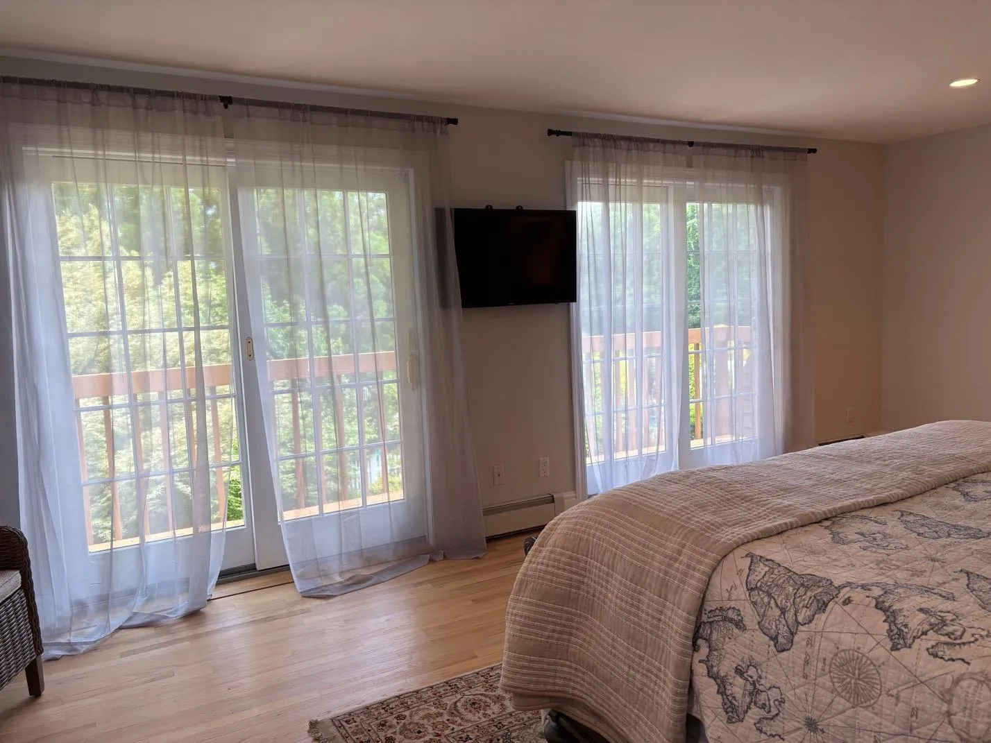 Bedroom with wood finished floors, a baseboard heating unit, access to exterior, and recessed lighting Bedroom with wood finished floors, a baseboard heating unit, access to exterior, and recessed lighting