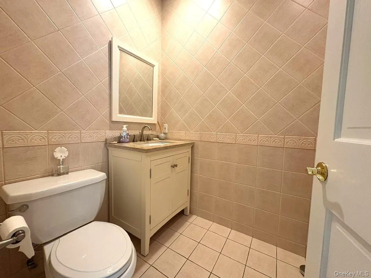 Bathroom featuring vanity, tile patterned flooring, and tile walls Bathroom featuring vanity, tile patterned flooring, and tile walls