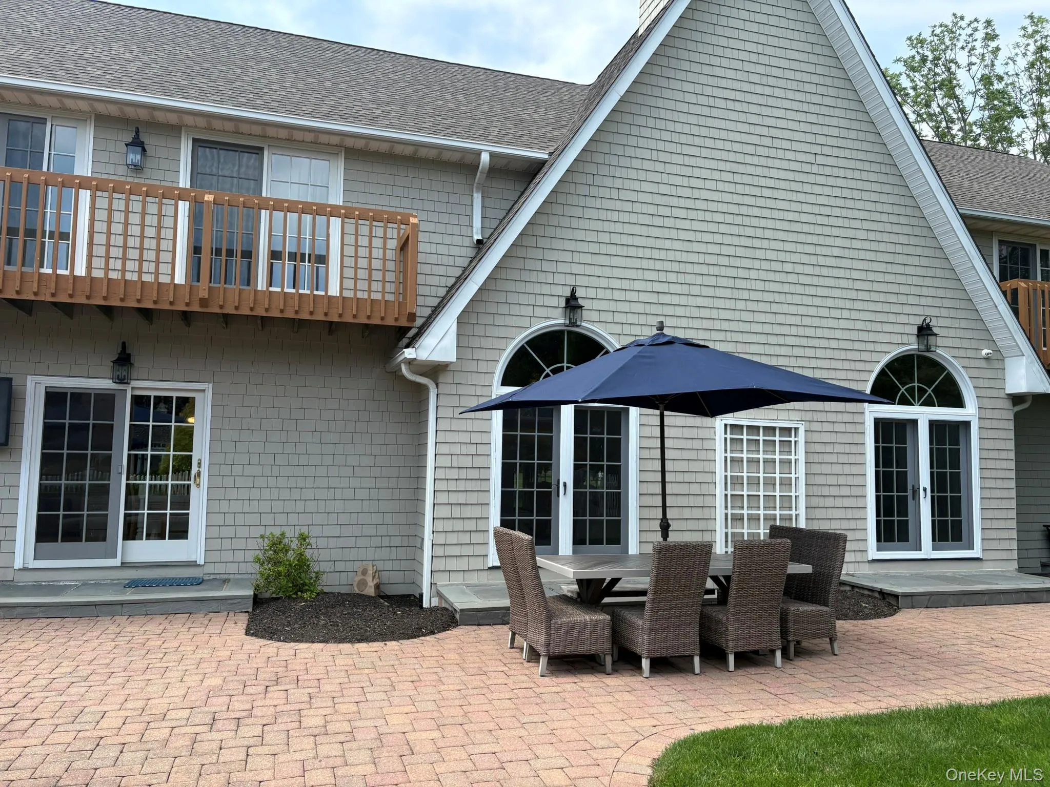 Back of house with french doors, a patio area, a shingled roof, and a balcony Back of house with french doors, a patio area, a shingled roof, and a balcony