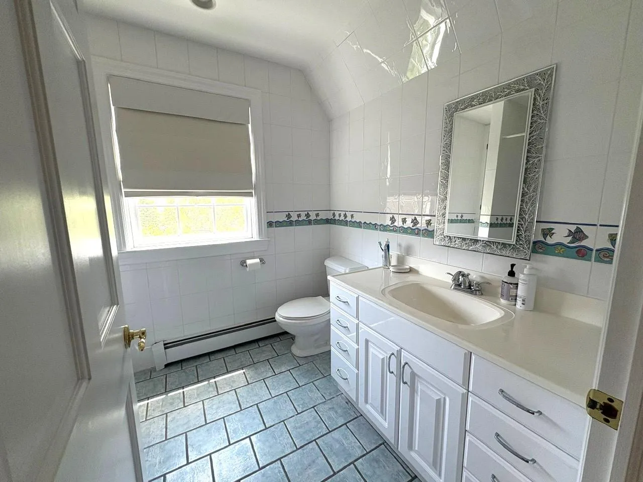Bathroom with a baseboard heating unit, tile walls, vanity, and tile patterned floors Bathroom with a baseboard heating unit, tile walls, vanity, and tile patterned floors