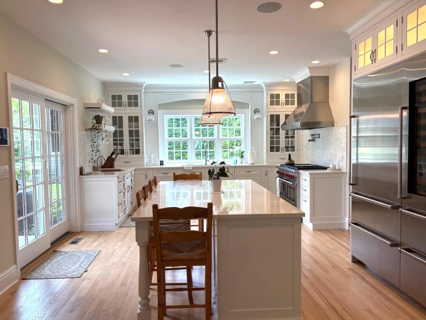 Kitchen with premium appliances, wall chimney exhaust hood, decorative backsplash, light countertops, and recessed lighting Kitchen with premium appliances, wall chimney exhaust hood, decorative backsplash, light countertops, and recessed lighting
