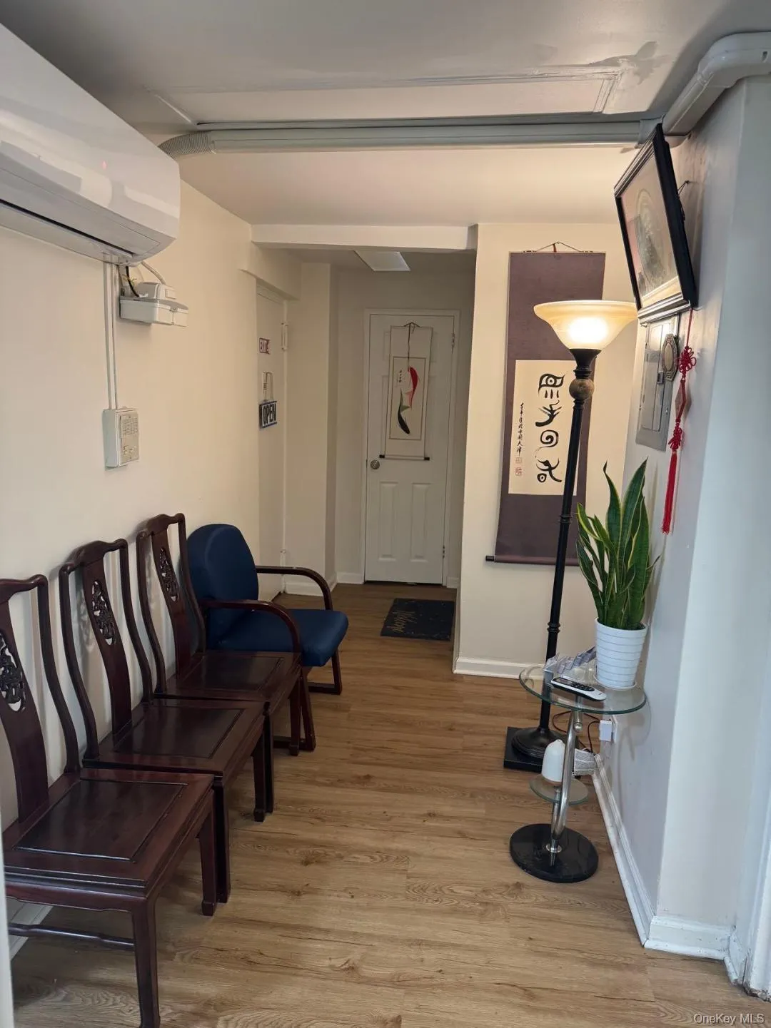Living area with a wall mounted AC and light wood-style floors Living area with a wall mounted AC and light wood-style floors