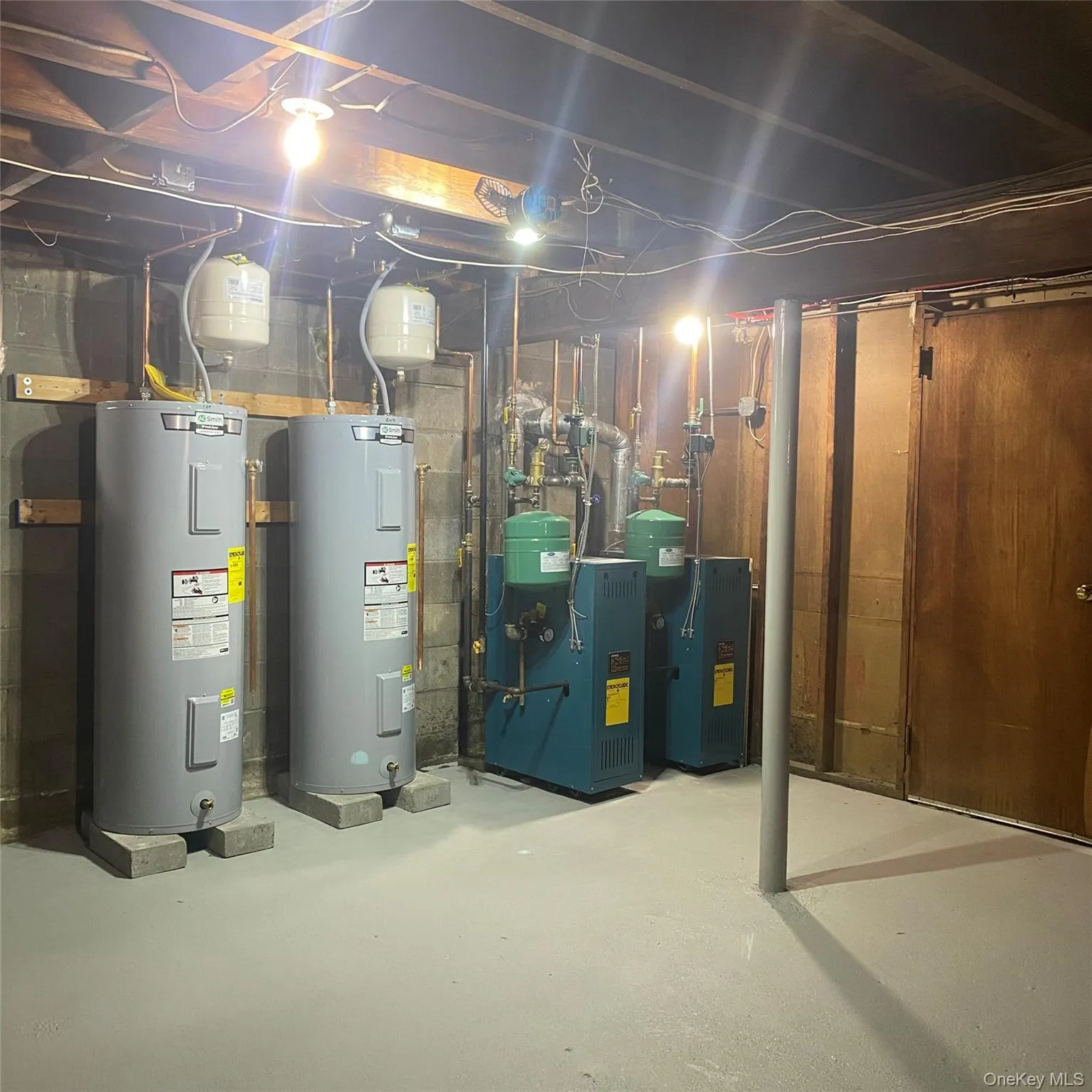 Unfinished below grade area with water heater and a heating unit Unfinished below grade area with water heater and a heating unit