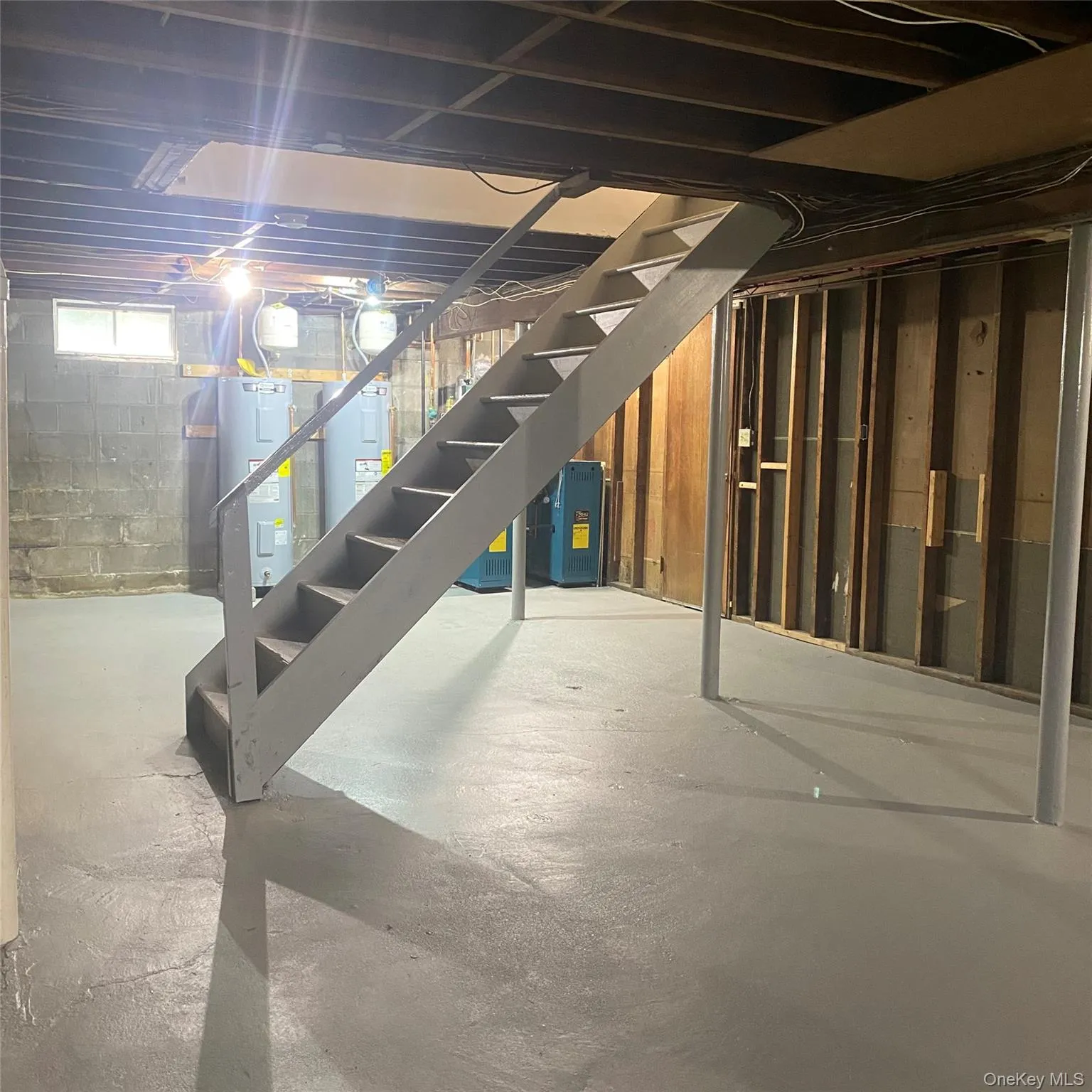 Below grade area with water heater and stairway to first floor Below grade area with water heater and stairway to first floor