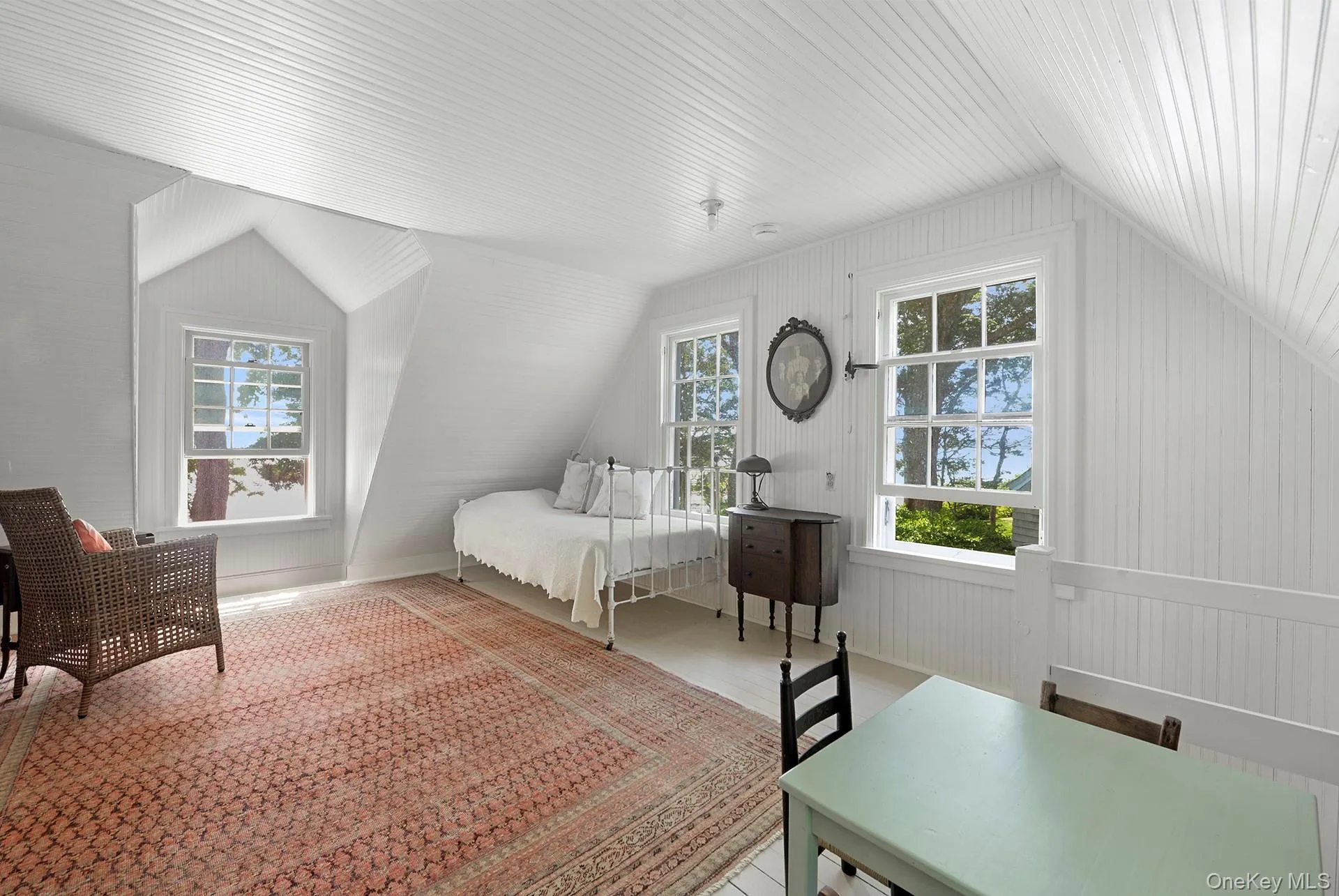 Bedroom with vaulted ceiling, multiple windows, and wood finished floors Bedroom with vaulted ceiling, multiple windows, and wood finished floors
