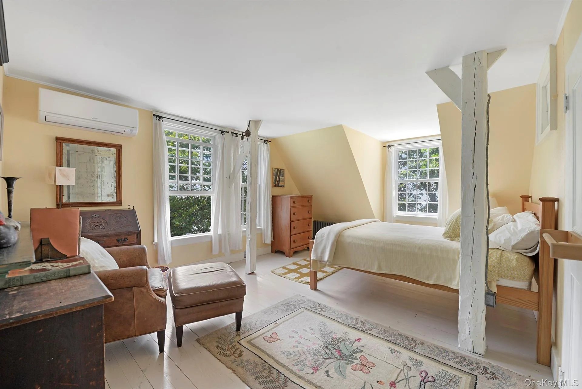 Bedroom with an AC wall unit, multiple windows, and light wood-type flooring Bedroom with an AC wall unit, multiple windows, and light wood-type flooring