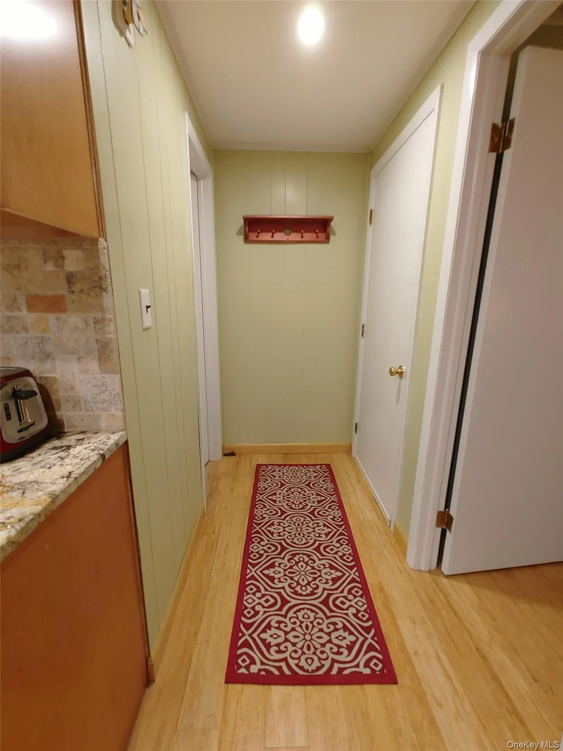 Hall with bamboo plank flooring, entry door access to basement garage Hall with bamboo plank flooring, entry door access to basement garage
