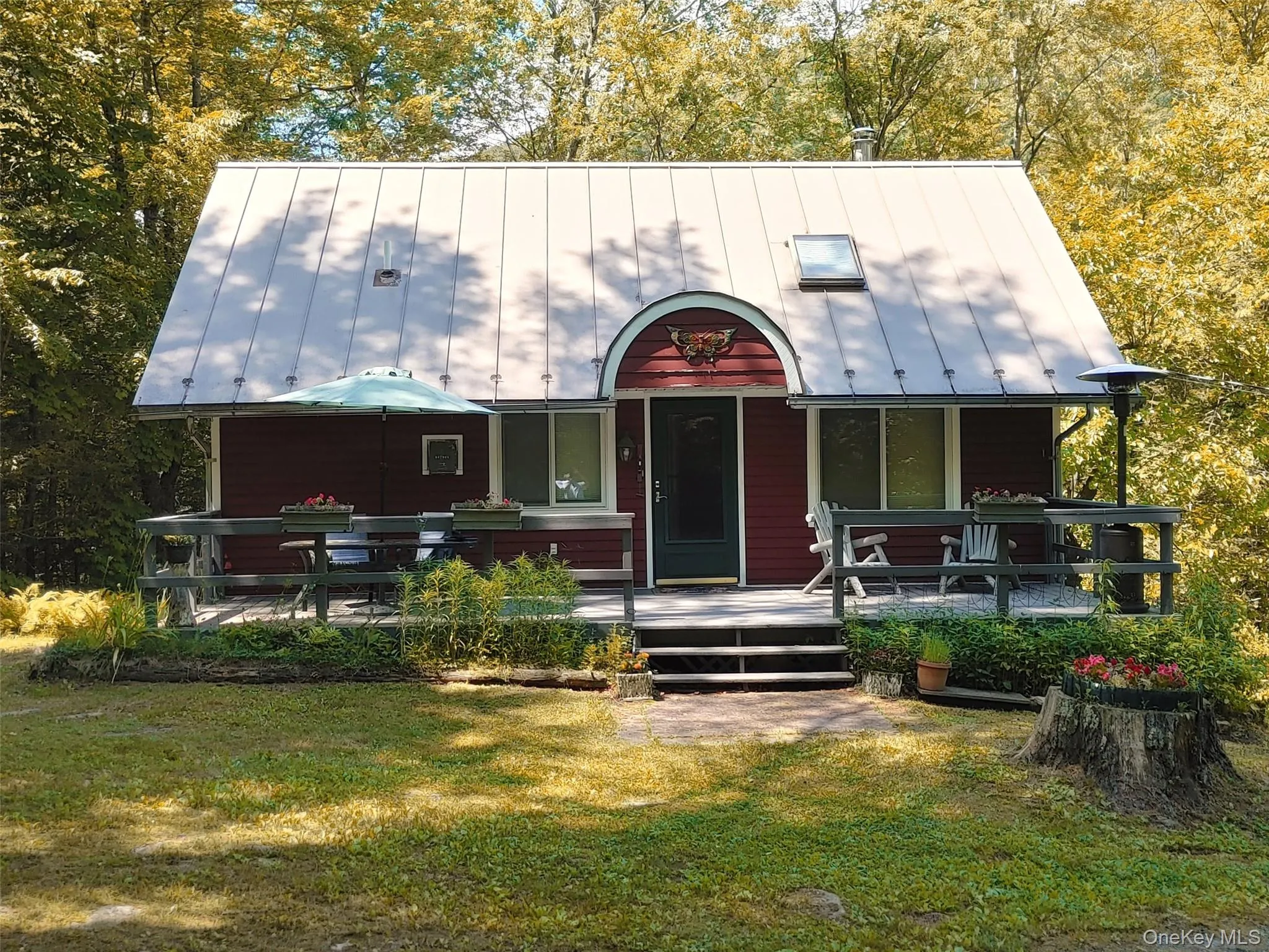 View of front of house featuring a standing seam roof, a front lawn, and a metal roof View of front of house featuring a standing seam roof, a front lawn, and a metal roof